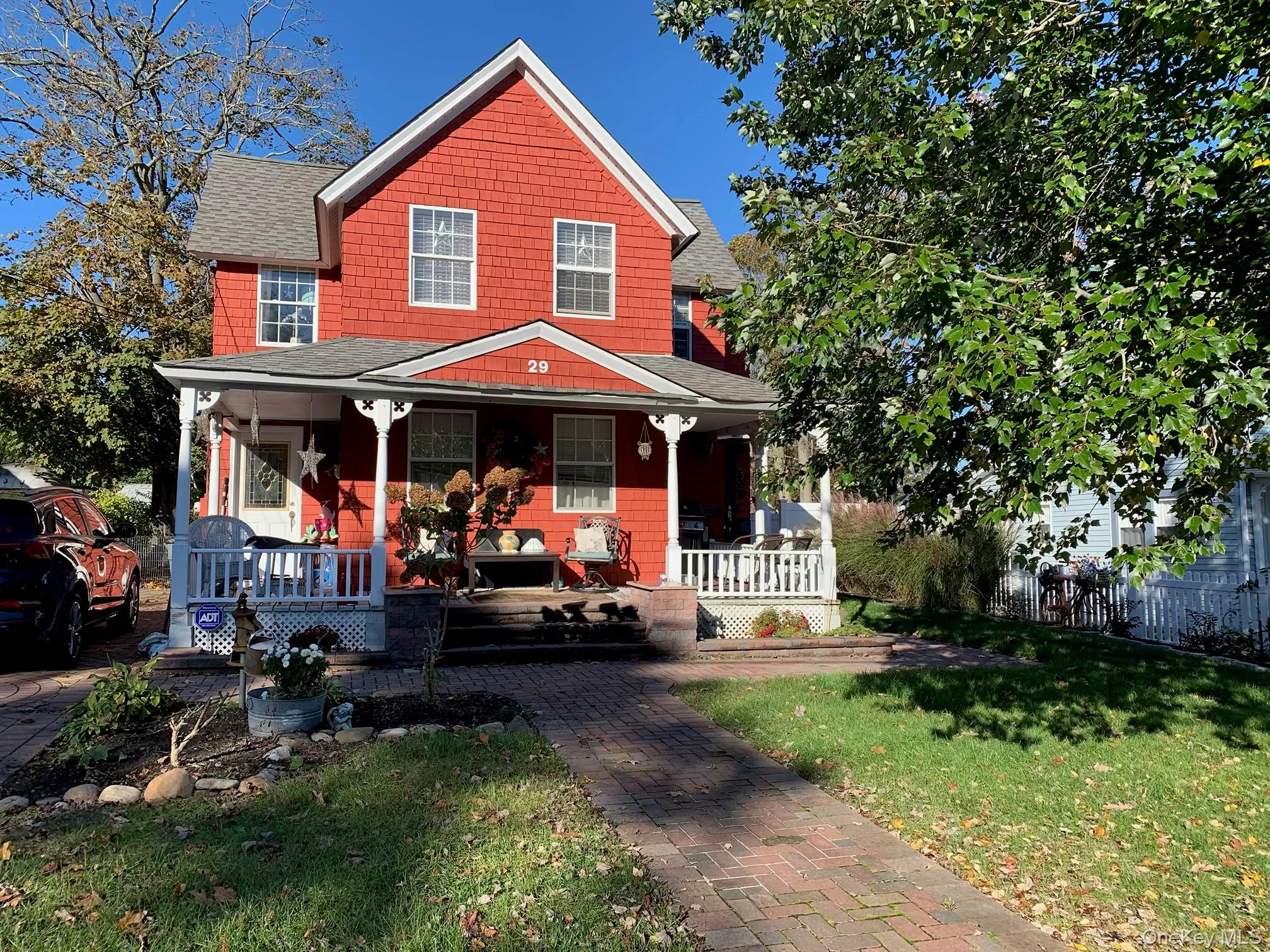 View of front of home featuring roof with shingles, covered porch, and a front yard View of front of home featuring roof with shingles, covered porch, and a front yard