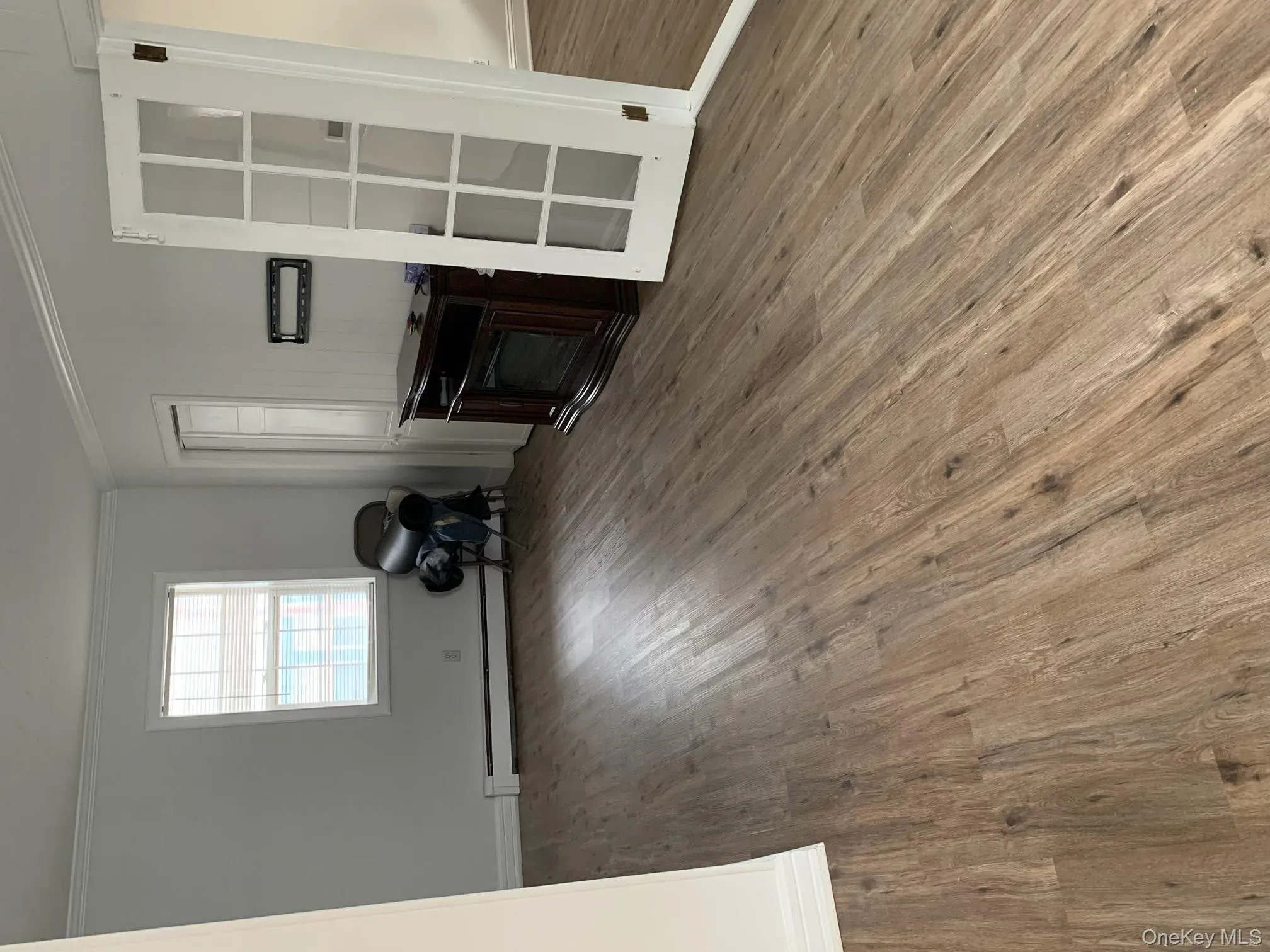 Unfurnished living room featuring ornamental molding, wood finished floors, a fireplace, and a baseboard radiator Unfurnished living room featuring ornamental molding, wood finished floors, a fireplace, and a baseboard radiator