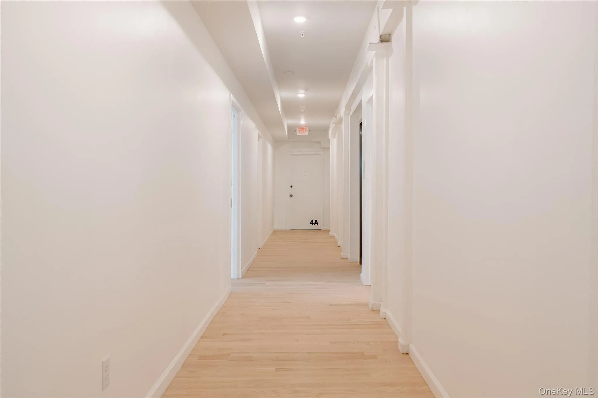 Corridor featuring light wood finished floors and baseboards Corridor featuring light wood finished floors and baseboards