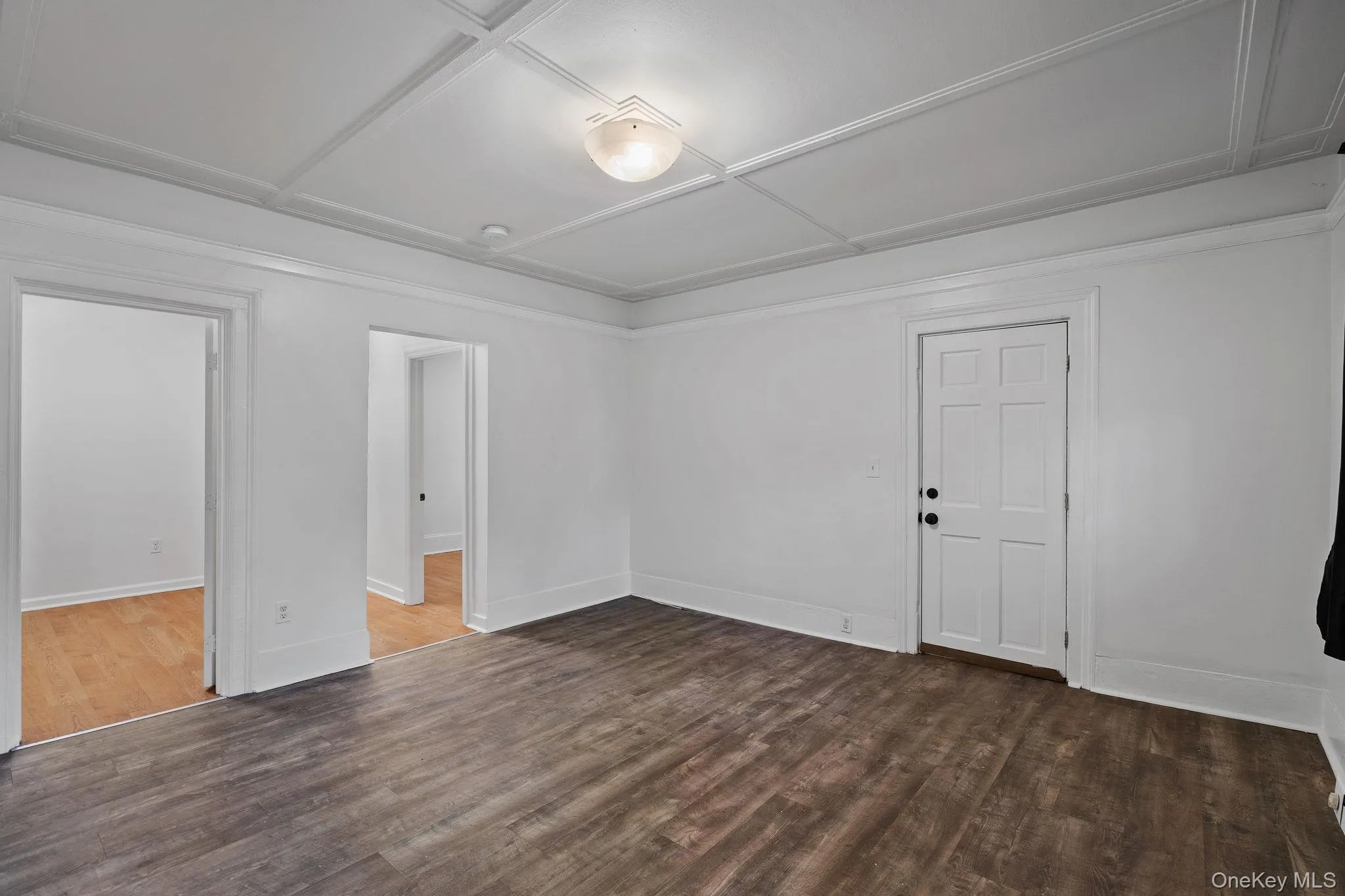 Spare room featuring dark wood-style flooring and baseboards Spare room featuring dark wood-style flooring and baseboards