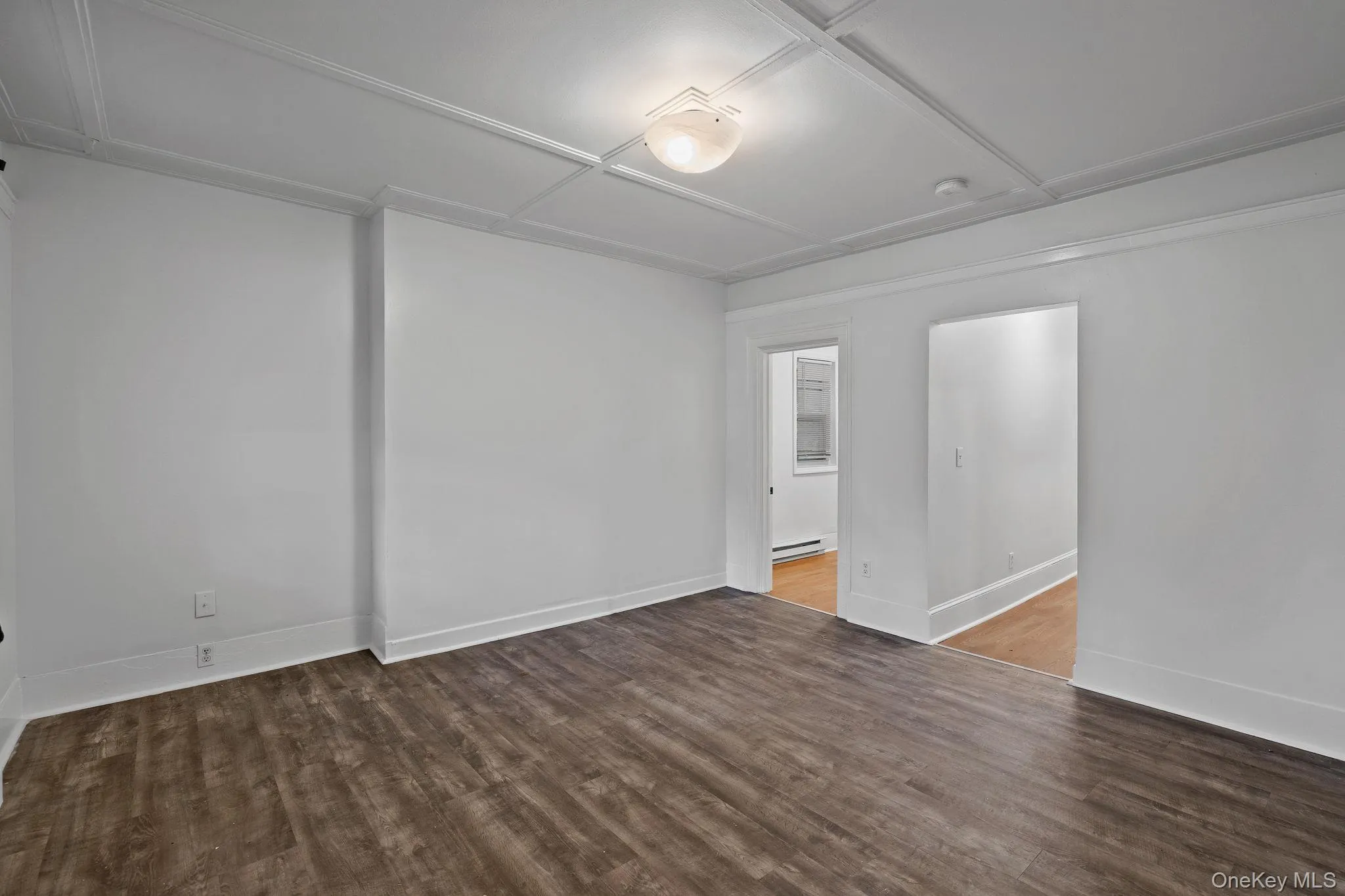 Unfurnished room with wood finished floors and baseboards Unfurnished room with wood finished floors and baseboards