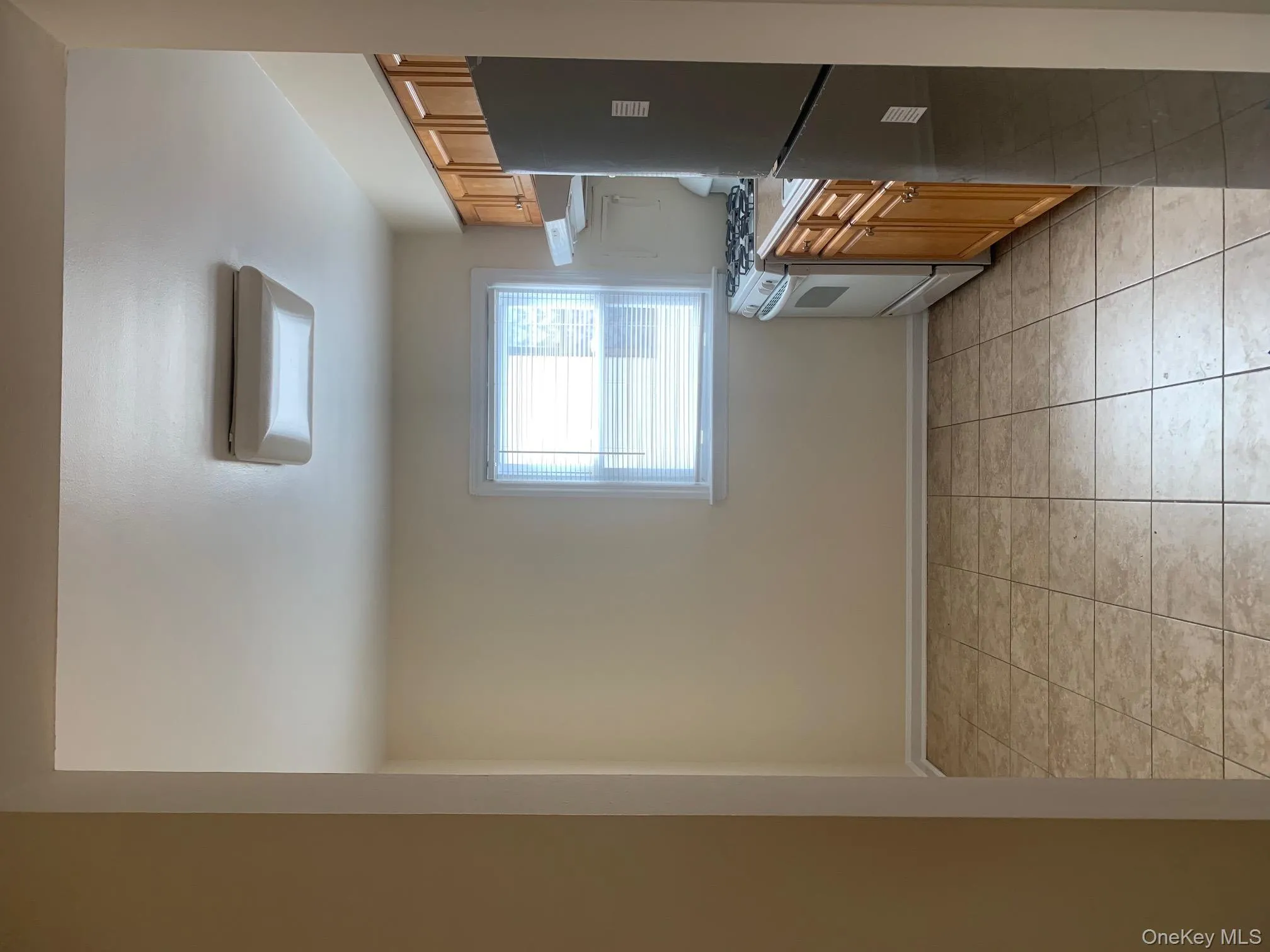 Kitchen with light countertops, refrigerator, stove, light tile patterned flooring, and extractor fan Kitchen with light countertops, refrigerator, stove, light tile patterned flooring, and extractor fan