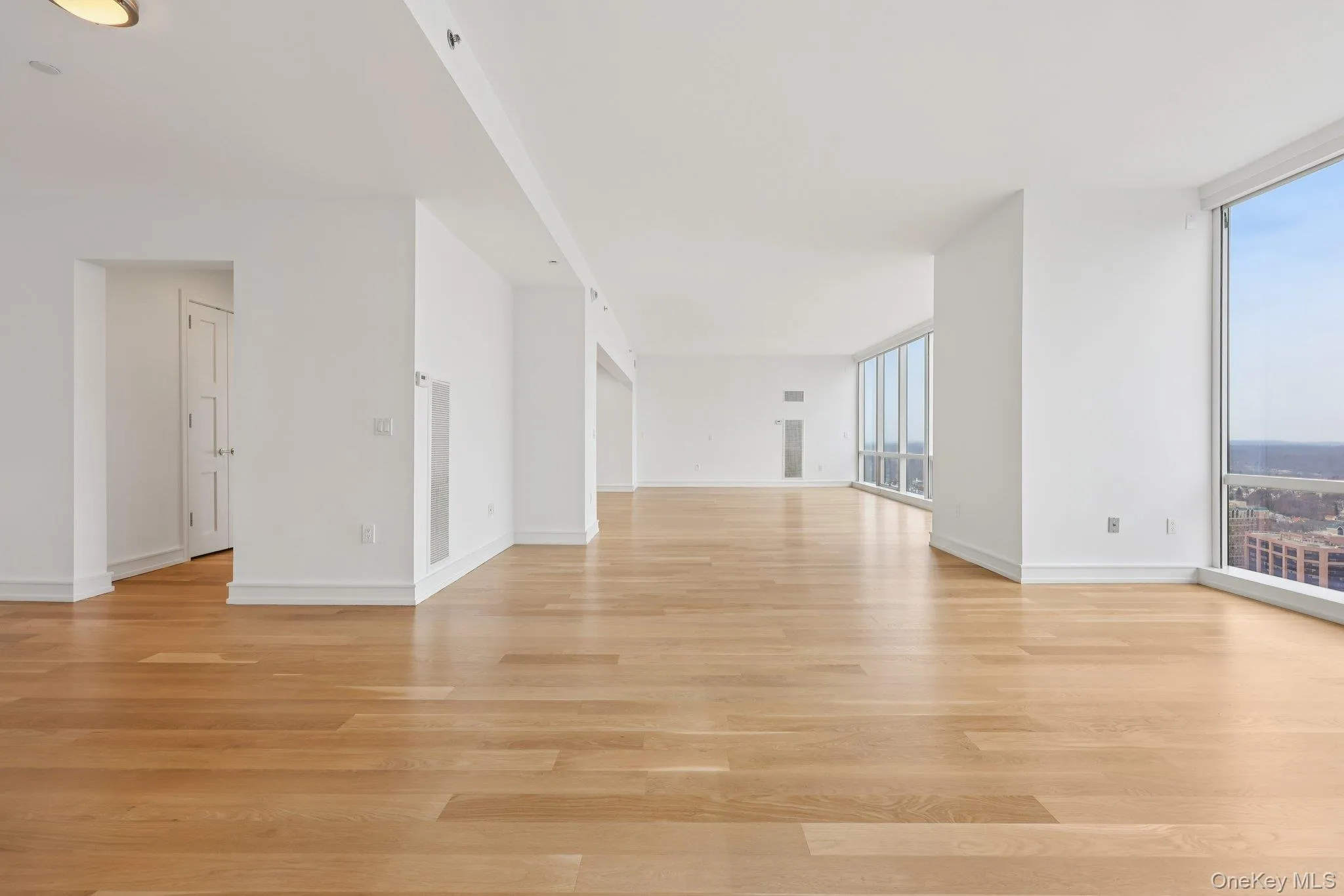 Empty room featuring floor to ceiling windows and light wood-style flooring Empty room featuring floor to ceiling windows and light wood-style flooring