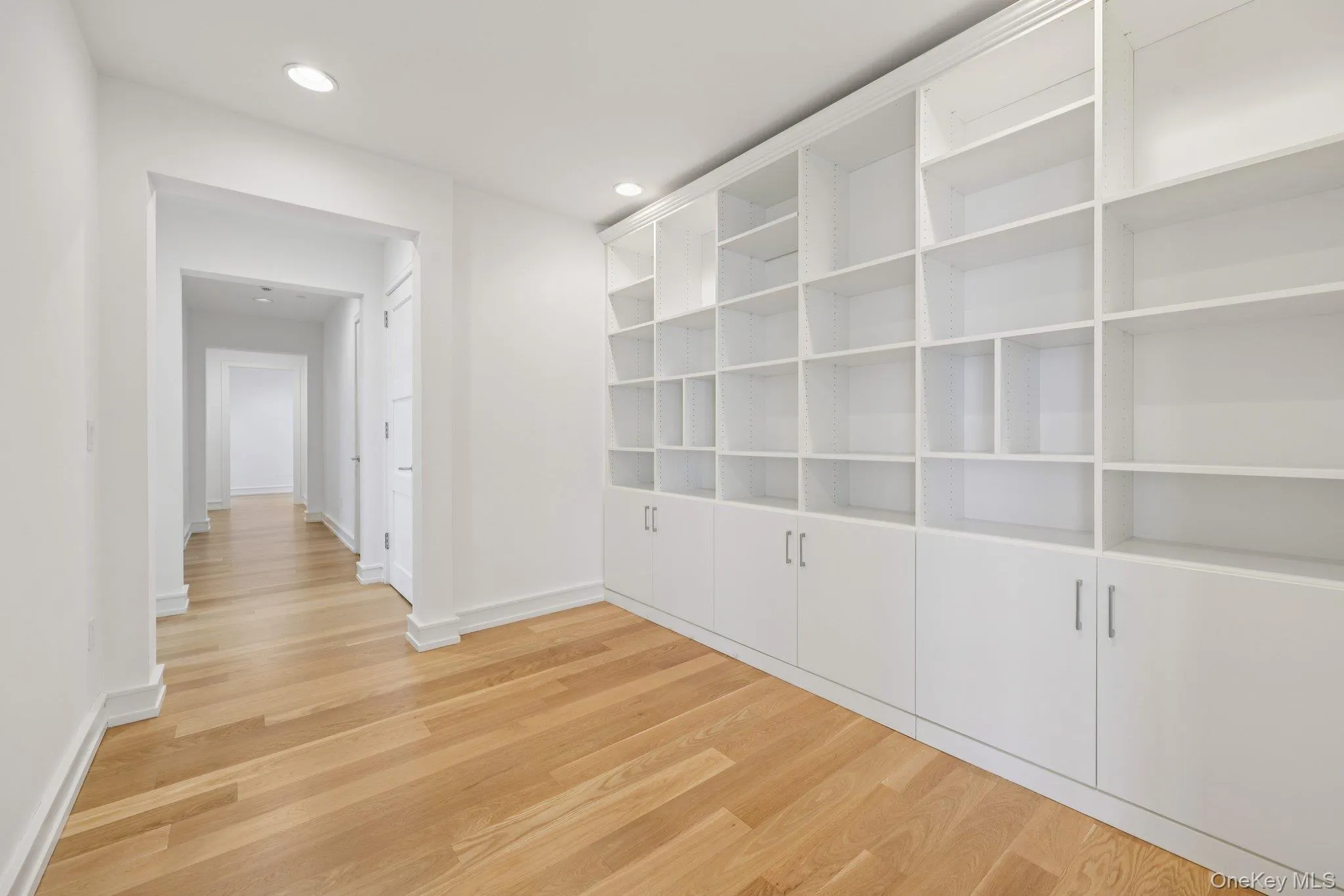 Hallway with light wood-style floors and recessed lighting Hallway with light wood-style floors and recessed lighting