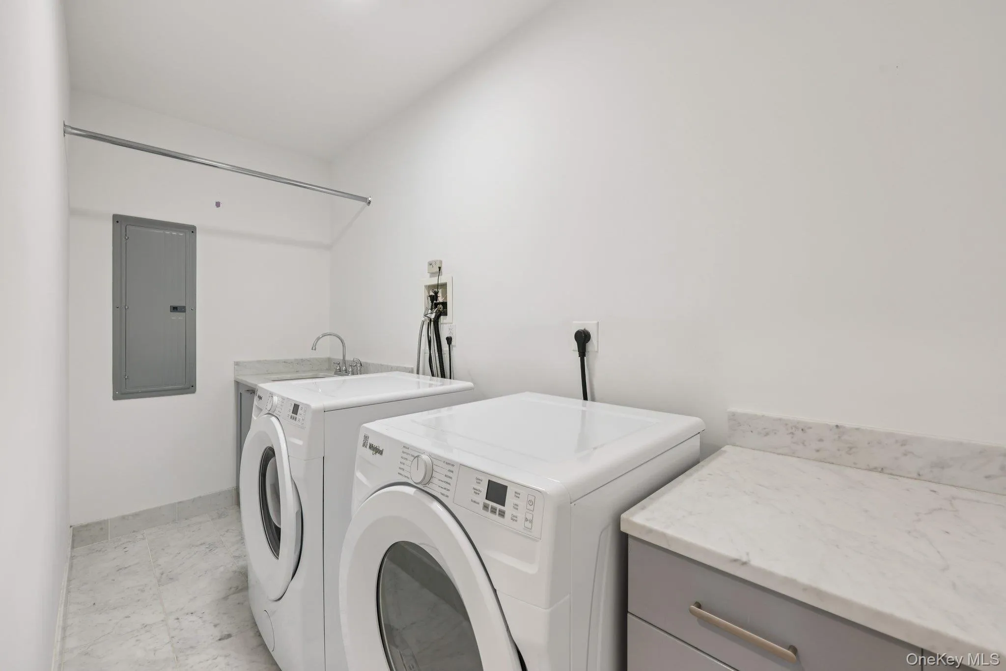 Washroom featuring electric panel, washing machine and clothes dryer, and cabinet space Washroom featuring electric panel, washing machine and clothes dryer, and cabinet space