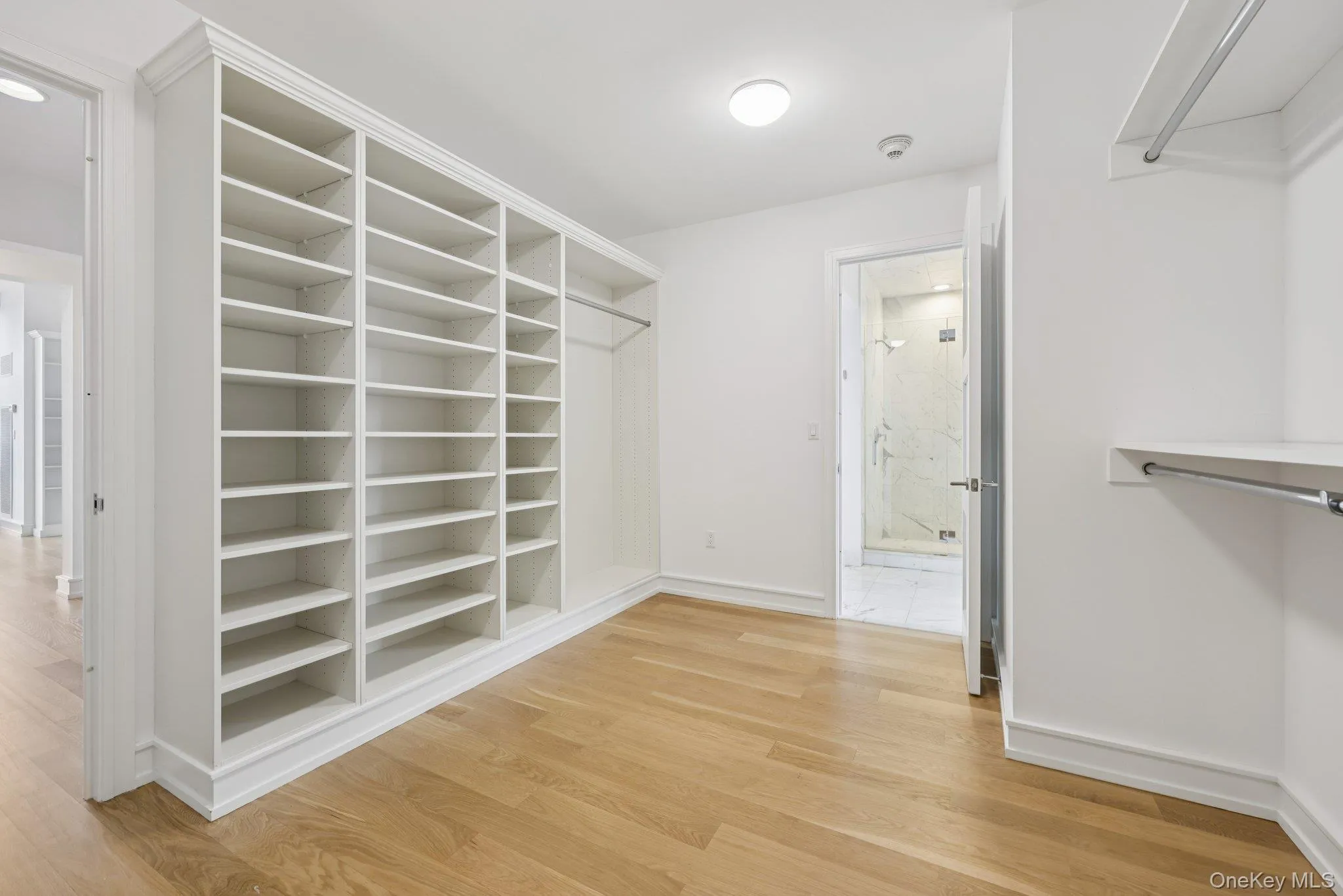 Walk in closet with light wood finished floors Walk in closet with light wood finished floors