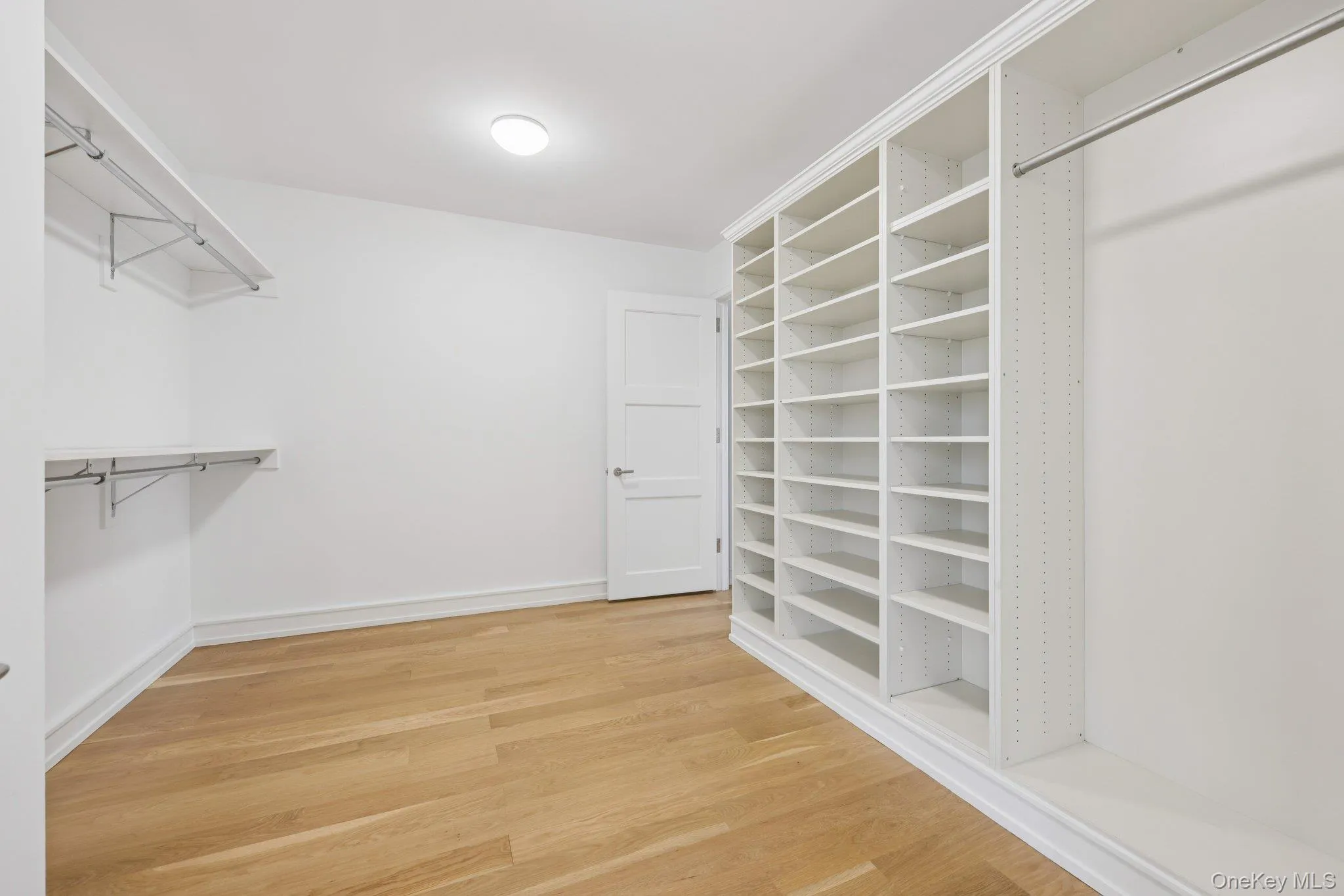 Spacious closet featuring light wood-type flooring Spacious closet featuring light wood-type flooring