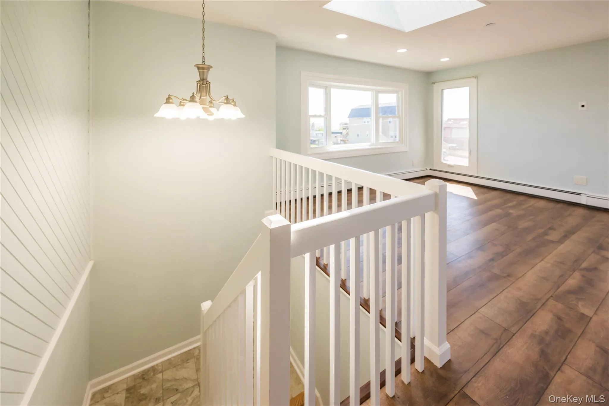Stairway featuring a skylight, recessed lighting, and wood finished floors Stairway featuring a skylight, recessed lighting, and wood finished floors