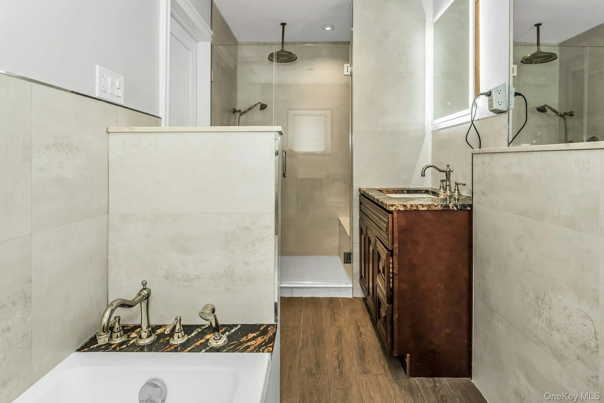 Bathroom featuring a stall shower, vanity, dark wood-type flooring, and a bath Bathroom featuring a stall shower, vanity, dark wood-type flooring, and a bath