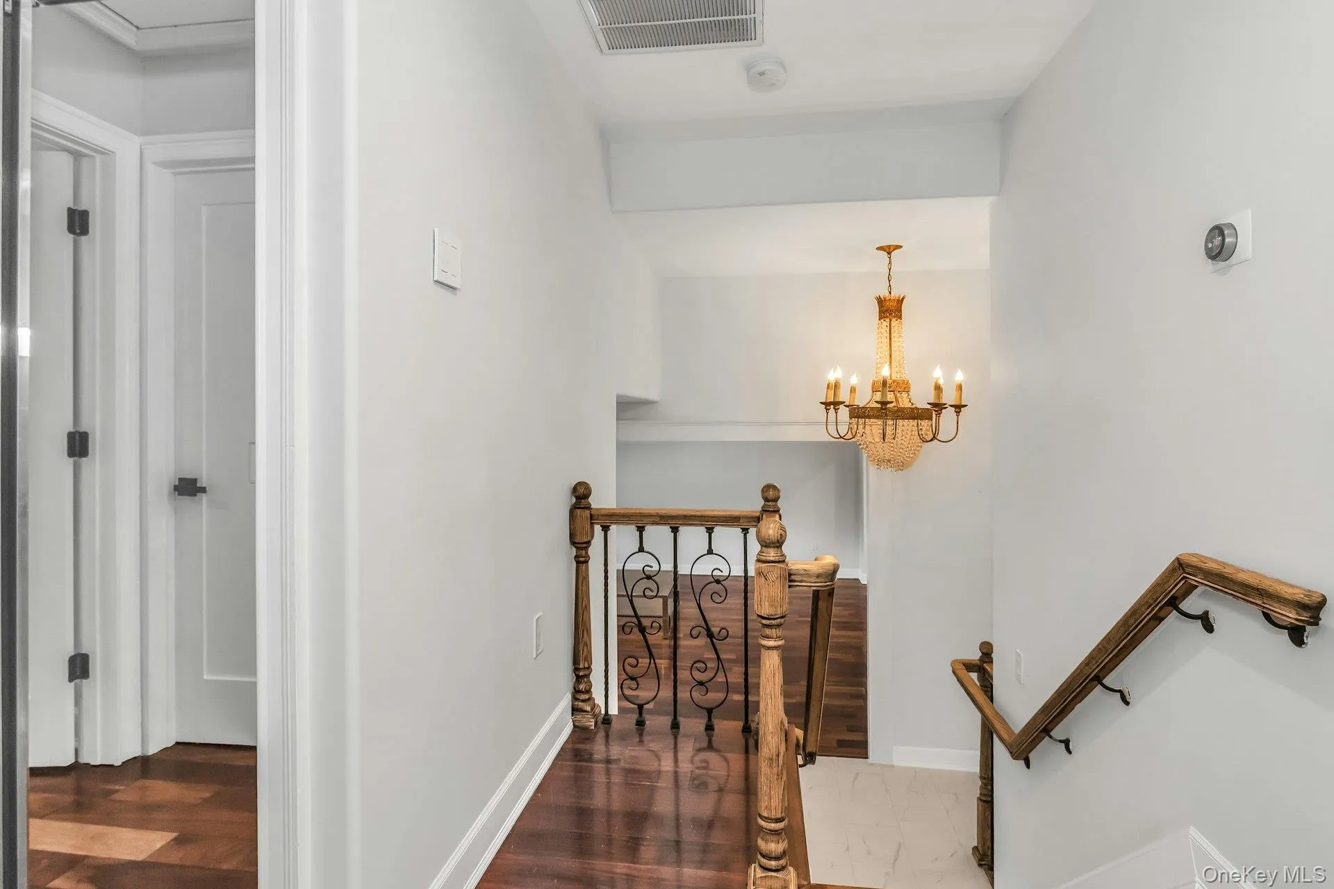 Staircase with a chandelier and wood finished floors Staircase with a chandelier and wood finished floors