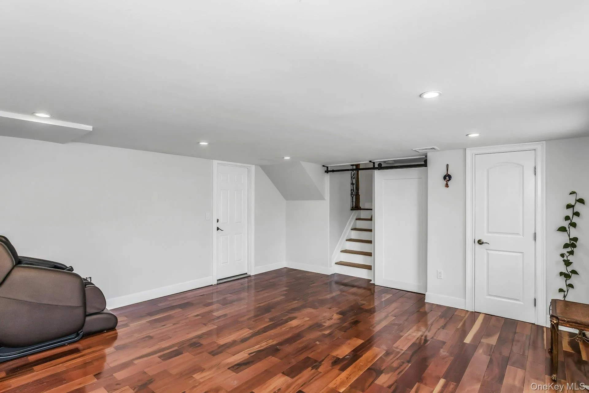 Finished below grade area with recessed lighting, stairs, and dark wood-type flooring Finished below grade area with recessed lighting, stairs, and dark wood-type flooring
