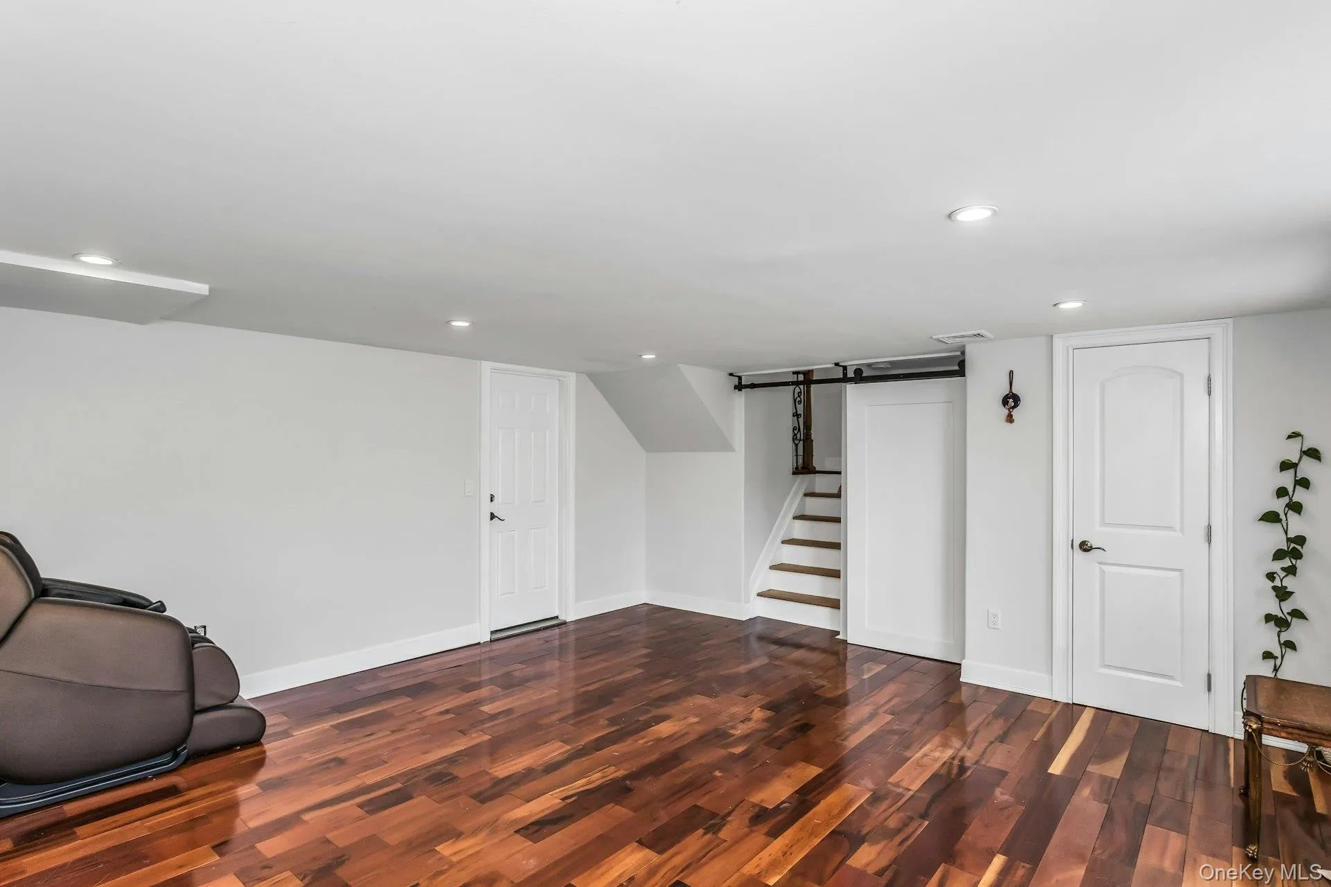 Finished below grade area with stairs, recessed lighting, and dark wood-type flooring Finished below grade area with stairs, recessed lighting, and dark wood-type flooring