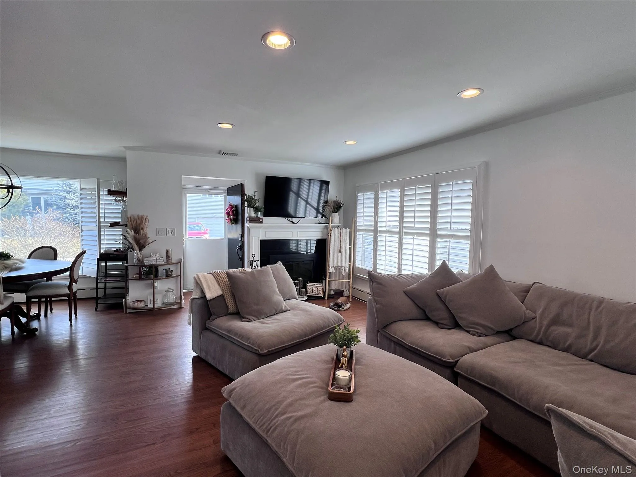 Living room featuring visible vents, a glass covered fireplace, dark wood finished floors, and recessed lighting Living room featuring visible vents, a glass covered fireplace, dark wood finished floors, and recessed lighting