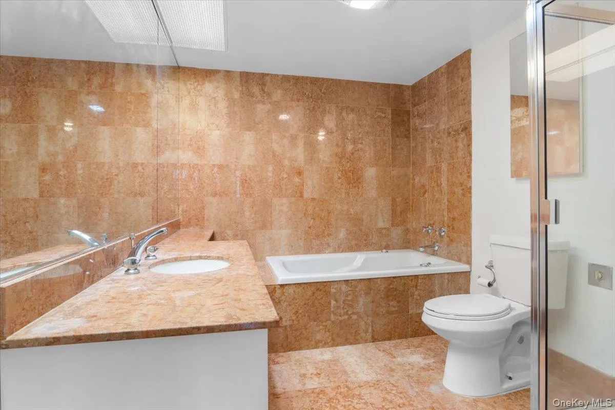 Bathroom with vanity, tile walls, a shower stall, tile patterned floors, and a bath Bathroom with vanity, tile walls, a shower stall, tile patterned floors, and a bath