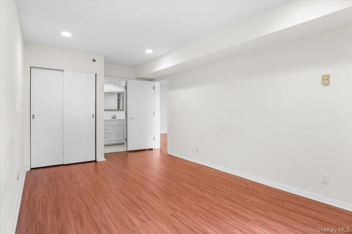 Unfurnished bedroom with a closet, light wood finished floors, ensuite bathroom, and recessed lighting Unfurnished bedroom with a closet, light wood finished floors, ensuite bathroom, and recessed lighting