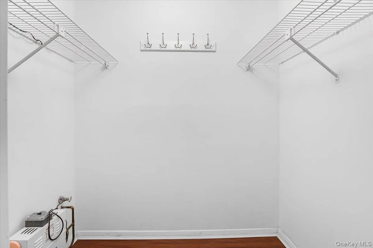 Walk in closet with dark wood finished floors Walk in closet with dark wood finished floors