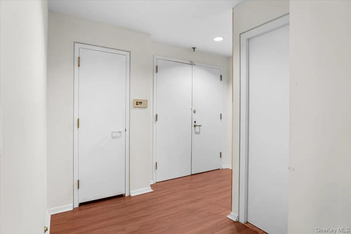 Hallway featuring wood finished floors and recessed lighting Hallway featuring wood finished floors and recessed lighting