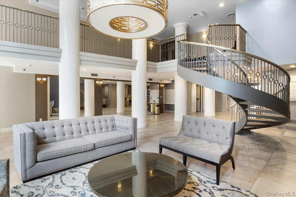 Community lobby with stairs, a towering ceiling, and recessed lighting Community lobby with stairs, a towering ceiling, and recessed lighting