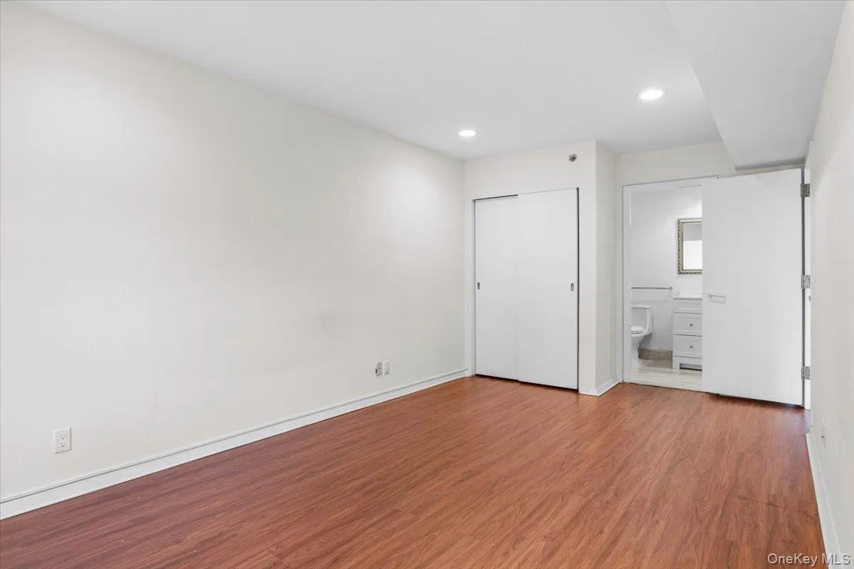 Unfurnished bedroom with wood finished floors, recessed lighting, a closet, and ensuite bathroom Unfurnished bedroom with wood finished floors, recessed lighting, a closet, and ensuite bathroom