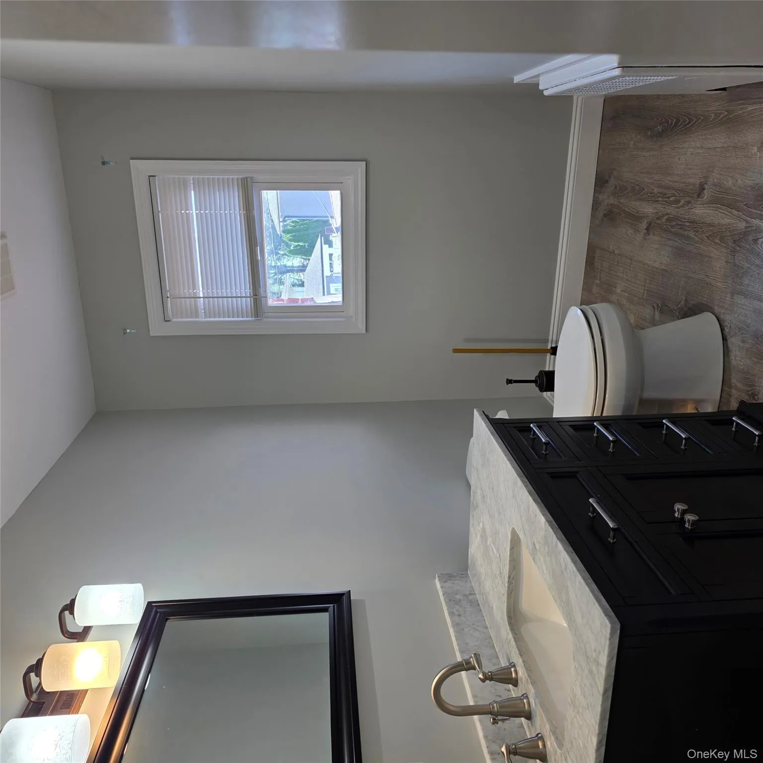 Half bathroom with dark wood-style flooring, vanity, and radiator heating unit Half bathroom with dark wood-style flooring, vanity, and radiator heating unit