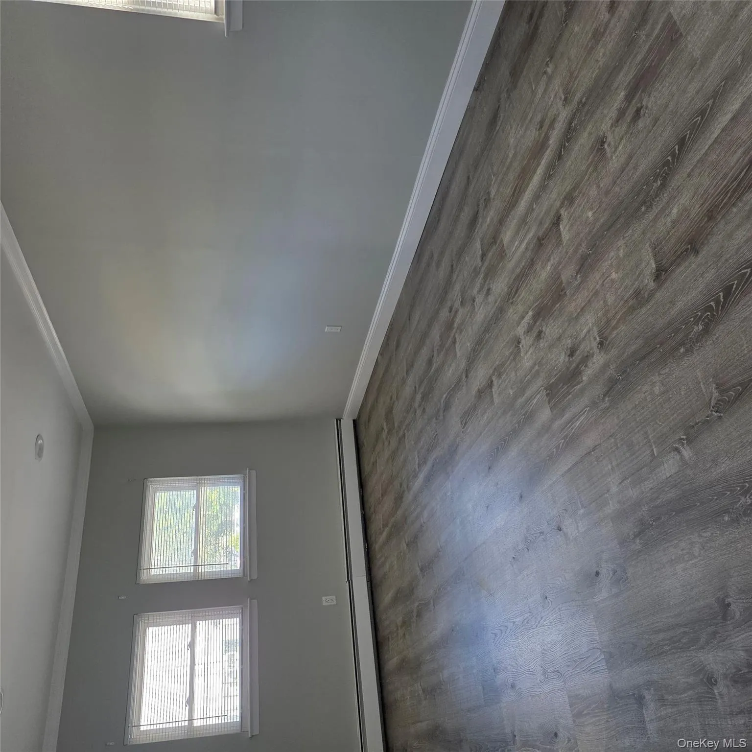 Empty room with crown molding, dark wood-type flooring, and a baseboard heating unit Empty room with crown molding, dark wood-type flooring, and a baseboard heating unit