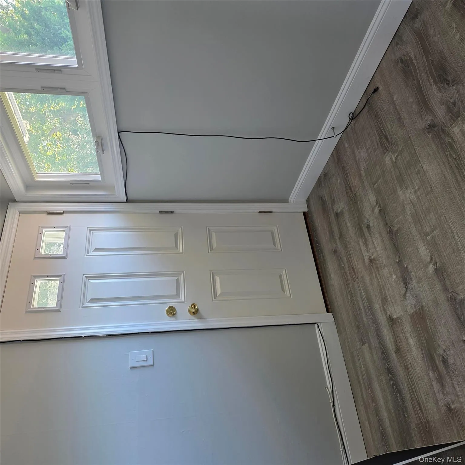 Doorway to outside with wood finished floors and baseboards Doorway to outside with wood finished floors and baseboards