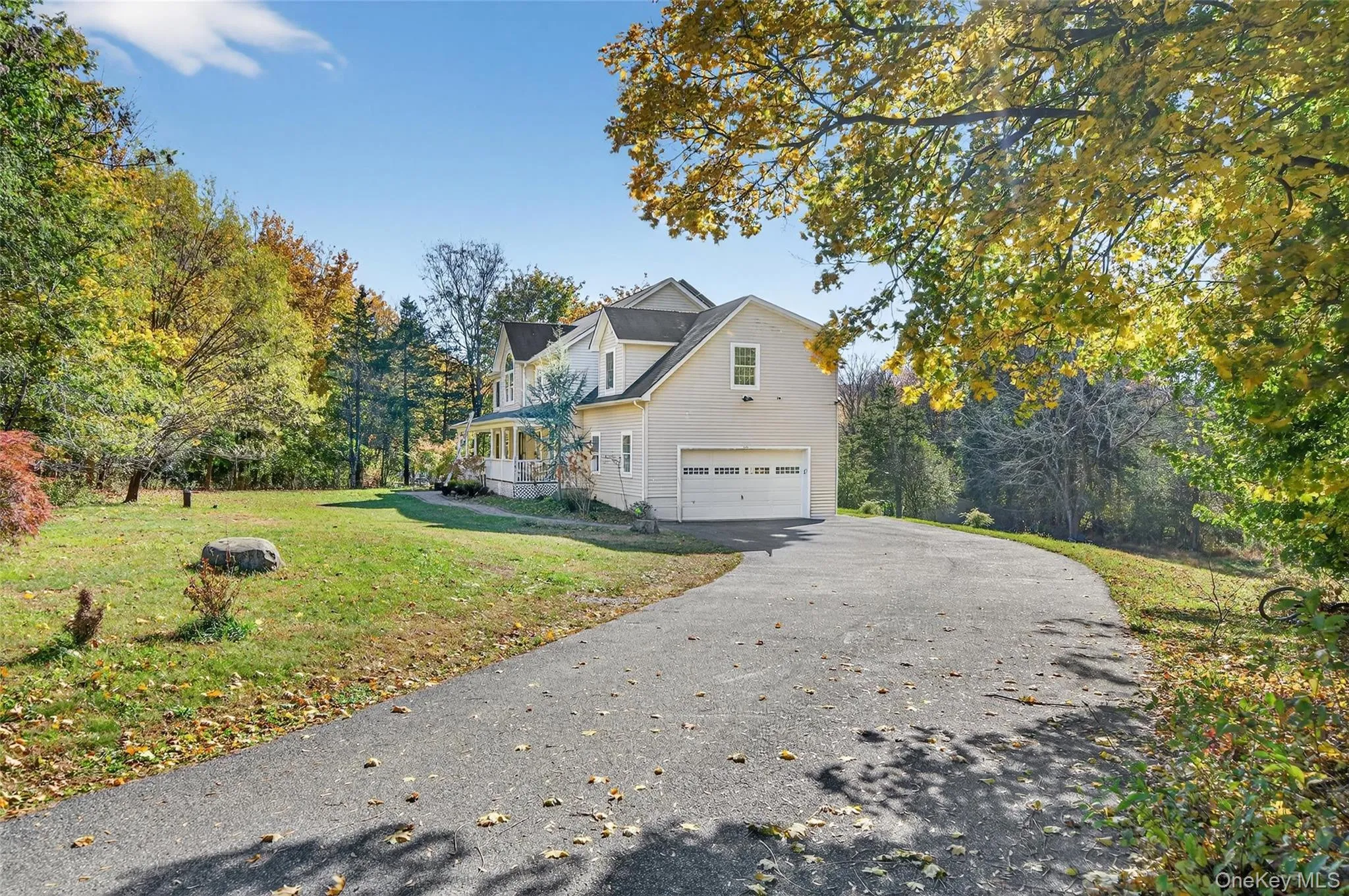 View of side of home featuring a lawn, driveway, and a garage View of side of home featuring a lawn, driveway, and a garage