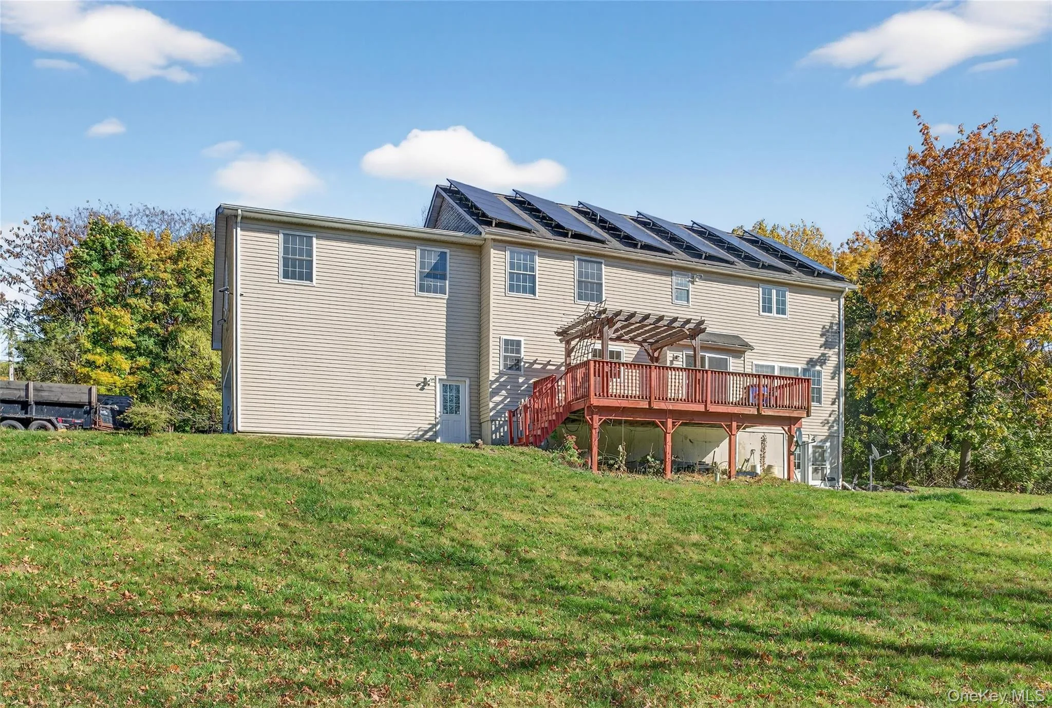 Back of property with a deck and a lawn Back of property with a deck and a lawn