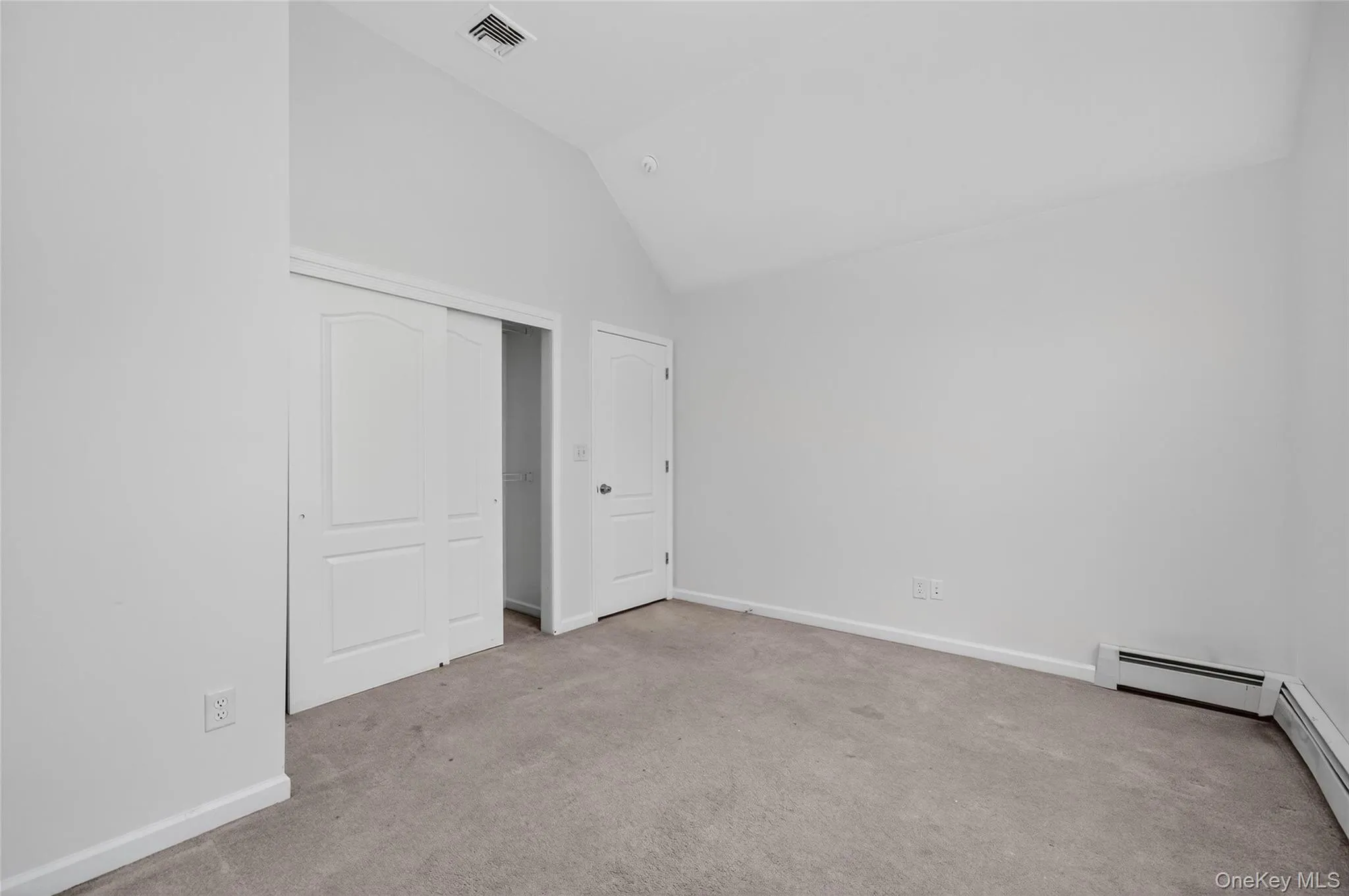 Unfurnished bedroom with light carpet, high vaulted ceiling, and a closet Unfurnished bedroom with light carpet, high vaulted ceiling, and a closet