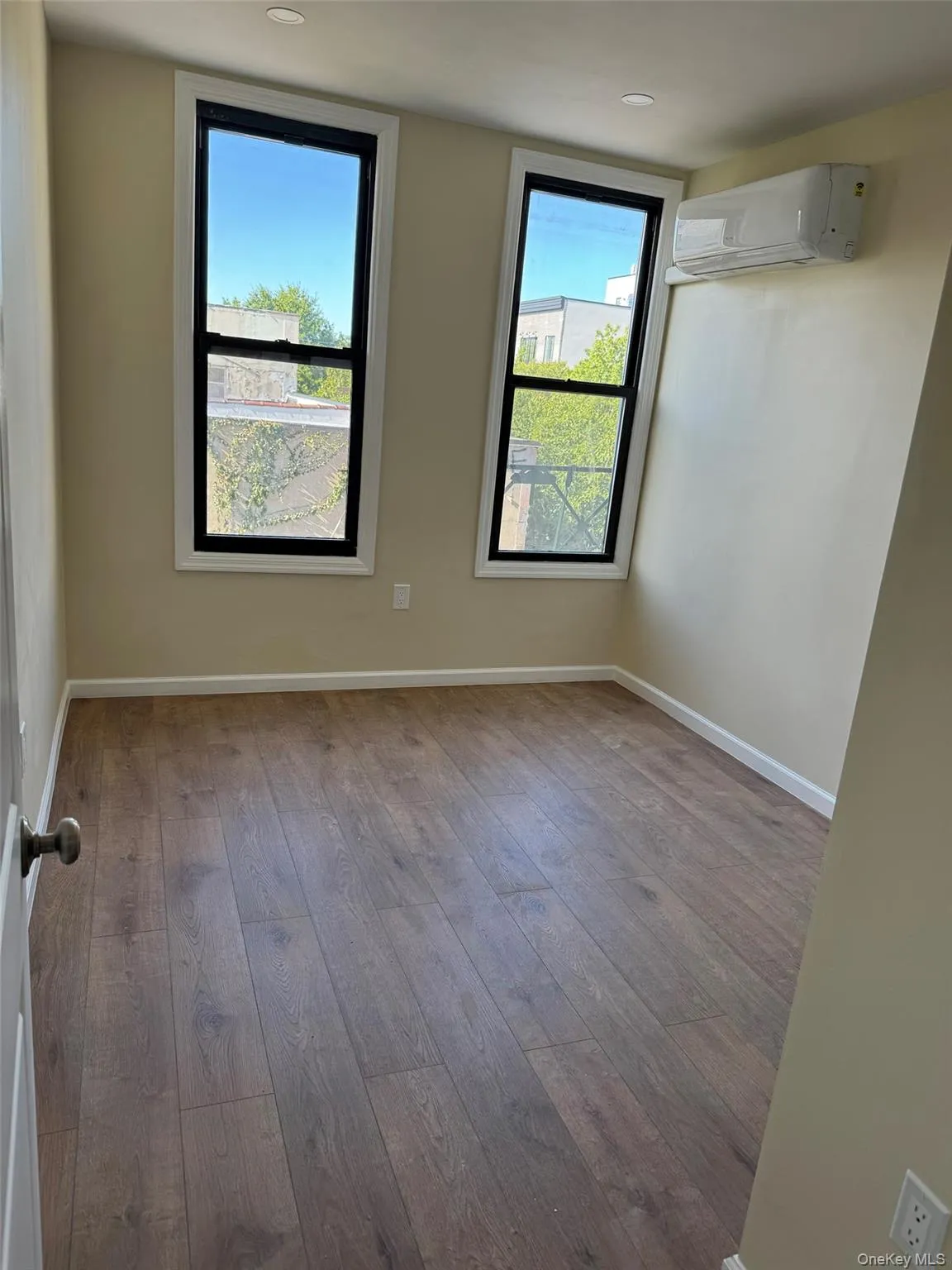 Spare room with light wood-type flooring and a wall unit AC Spare room with light wood-type flooring and a wall unit AC