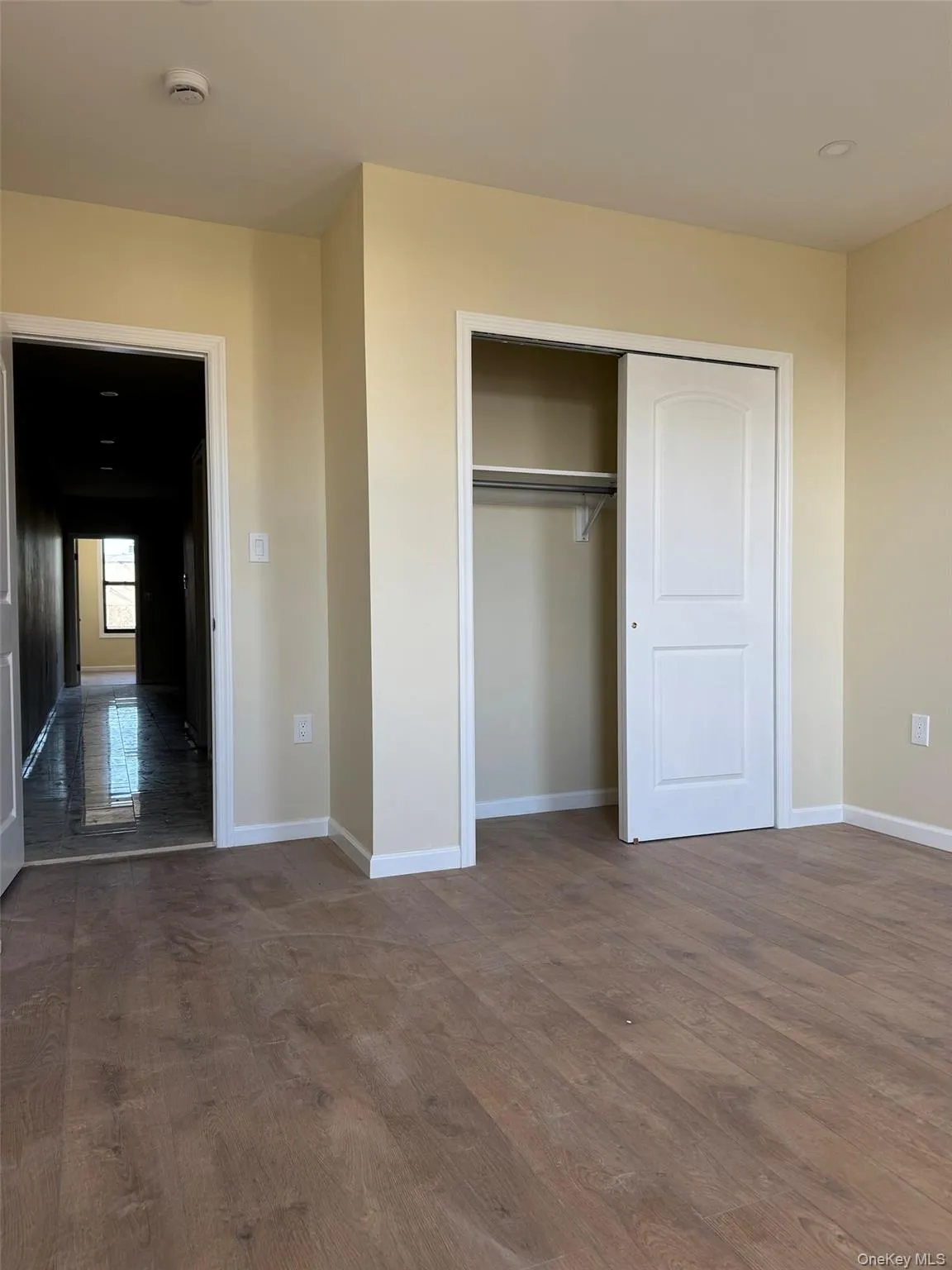 Unfurnished bedroom with dark wood-style flooring and a closet Unfurnished bedroom with dark wood-style flooring and a closet