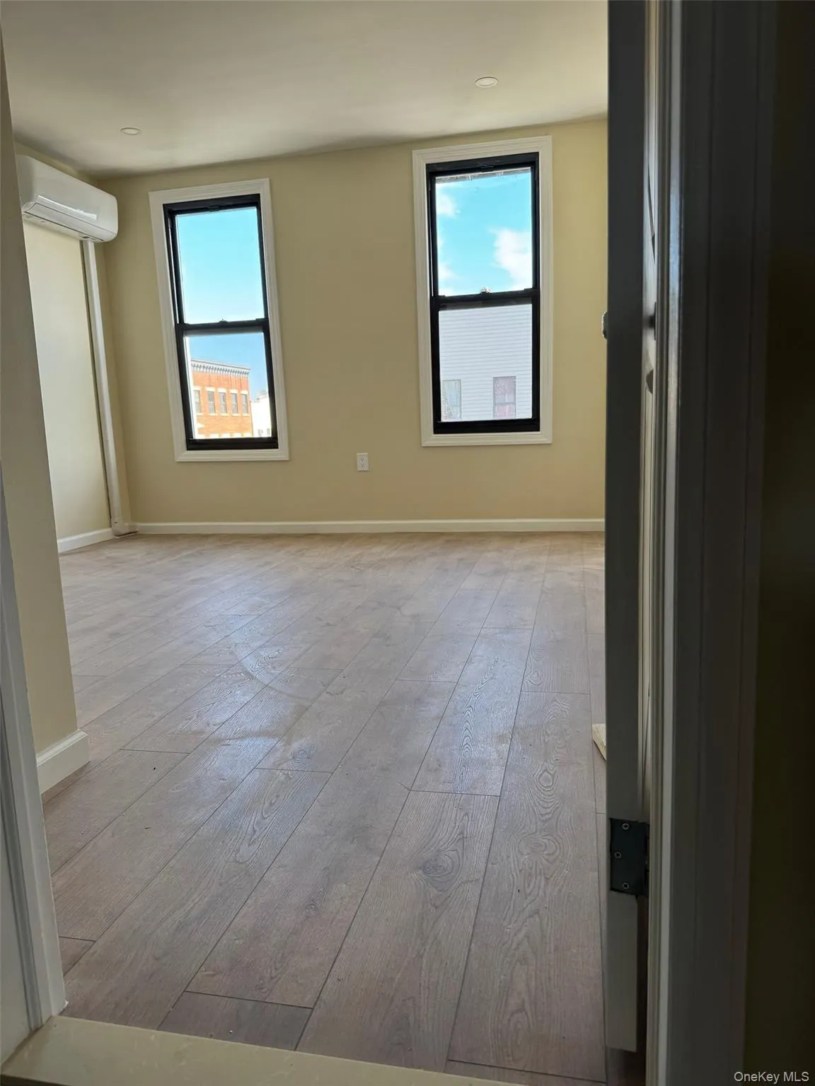 Unfurnished room featuring light wood-style flooring and a wall unit AC Unfurnished room featuring light wood-style flooring and a wall unit AC