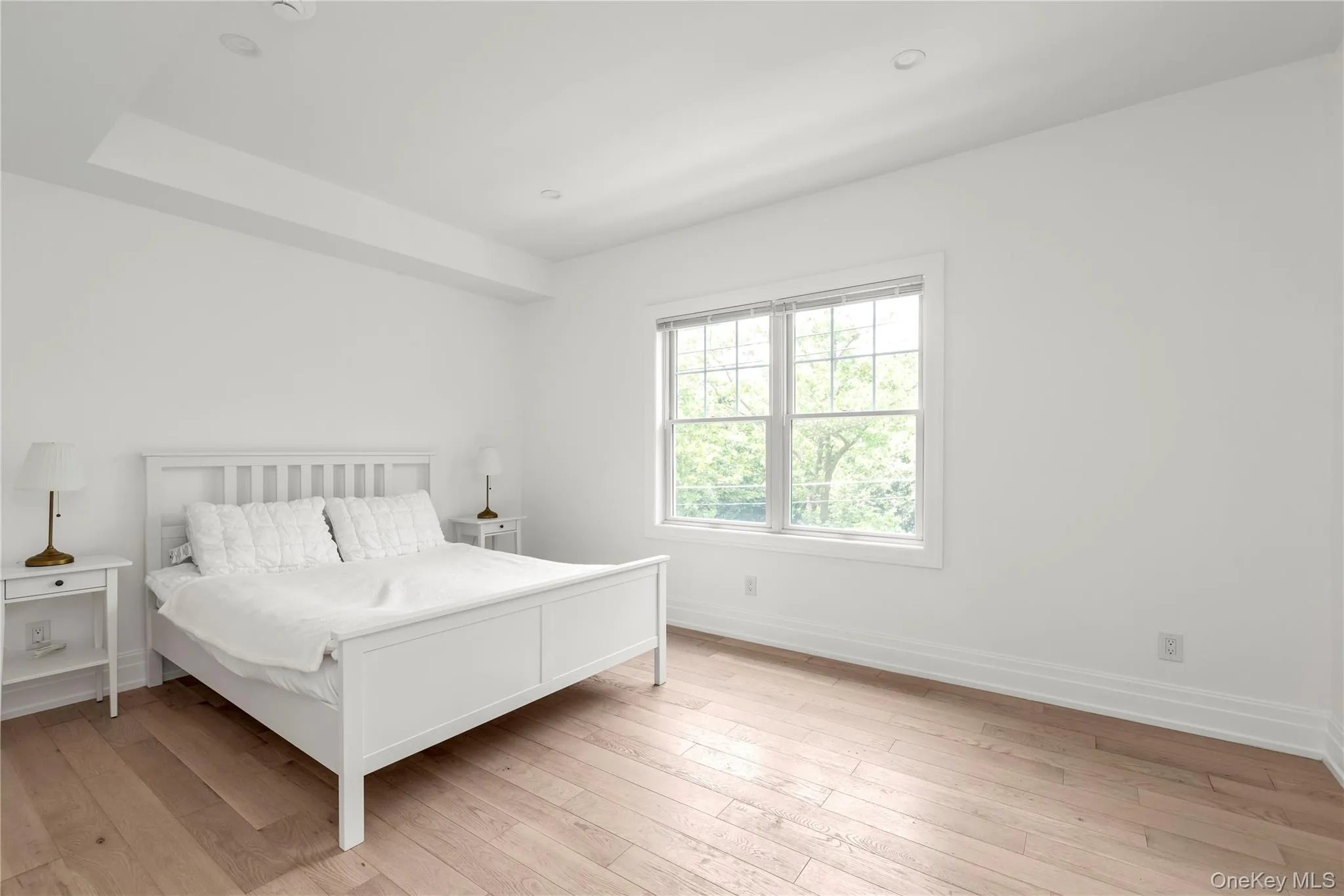 Bedroom with light wood finished floors and baseboards Bedroom with light wood finished floors and baseboards
