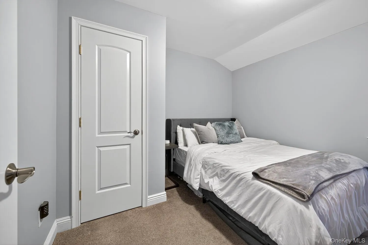 Carpeted bedroom featuring baseboards and vaulted ceiling Carpeted bedroom featuring baseboards and vaulted ceiling