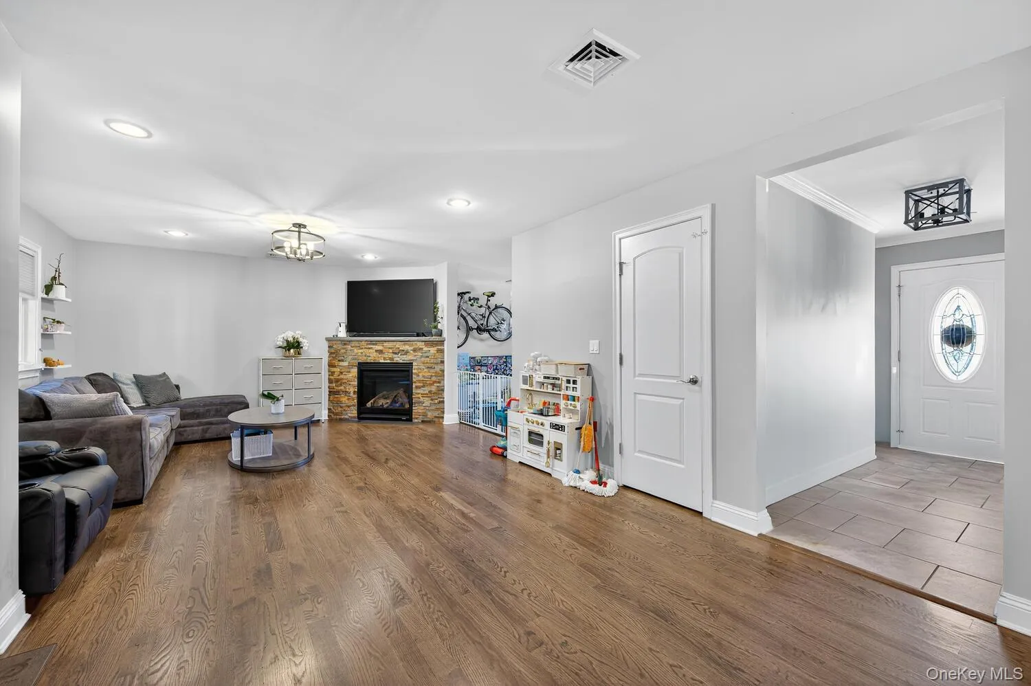 Living area with wood finished floors, a fireplace, recessed lighting, and a chandelier Living area with wood finished floors, a fireplace, recessed lighting, and a chandelier