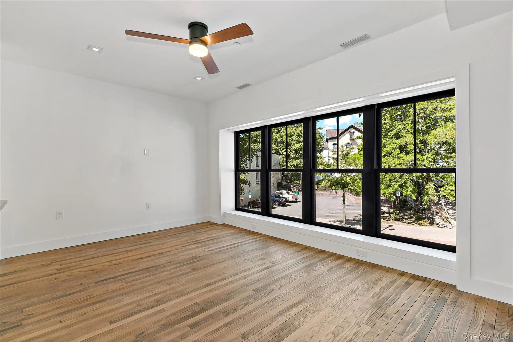 Living room with light wood-style flooring, a ceiling fan, and recessed lighting Living room with light wood-style flooring, a ceiling fan, and recessed lighting