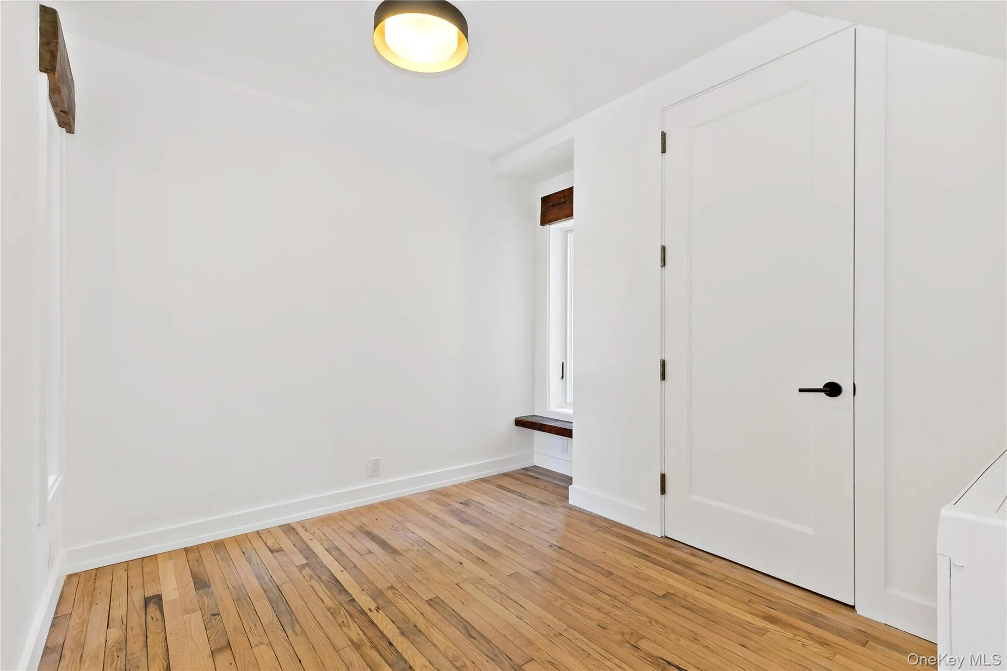 spare room/den with light wood-type flooring and baseboards spare room/den with light wood-type flooring and baseboards