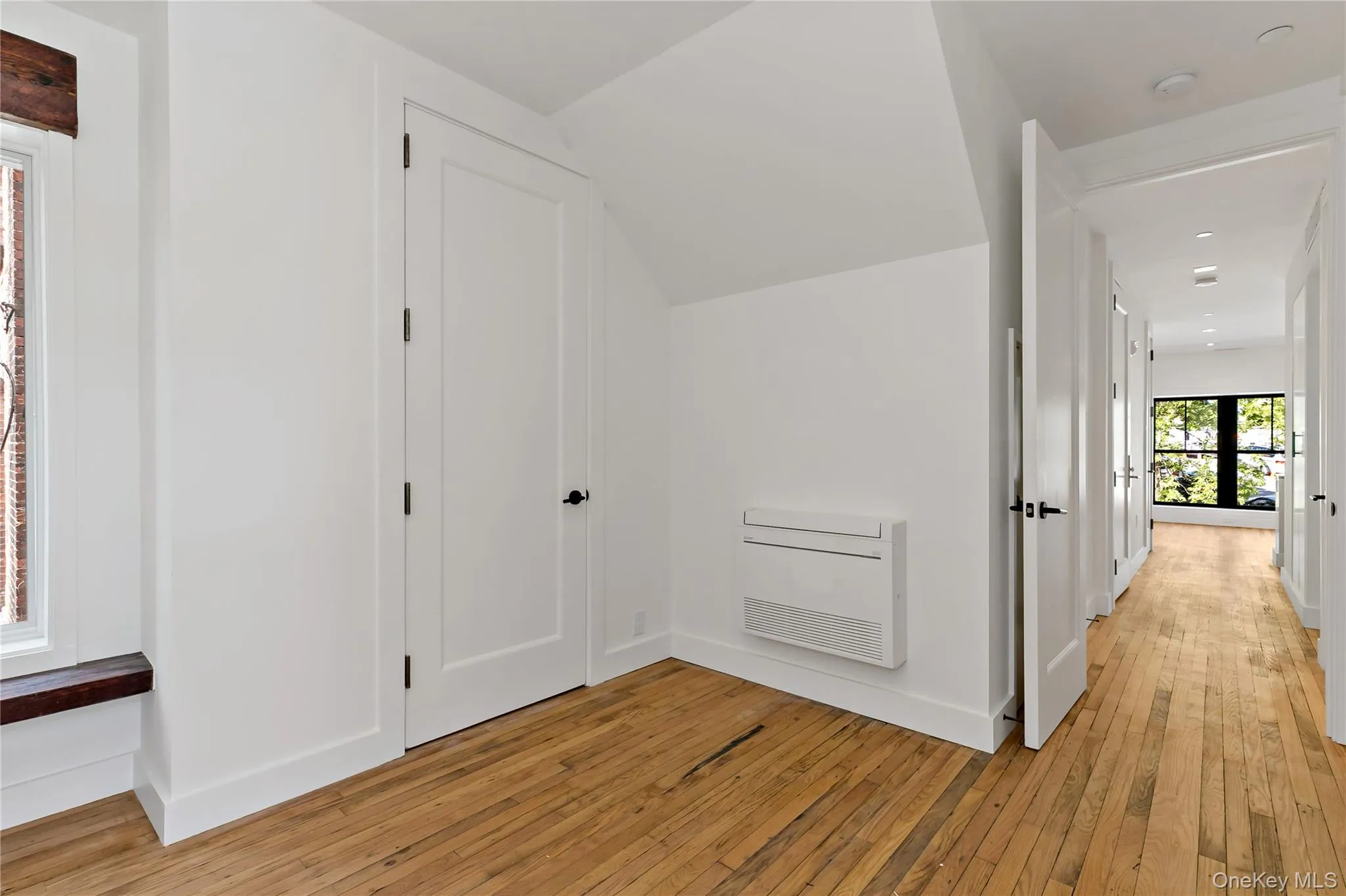 Additional living space with light wood-style flooring and heating unit Additional living space with light wood-style flooring and heating unit