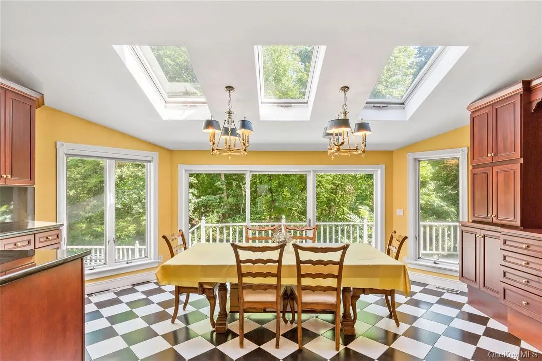 Oversized breakfast area overlooking property with cherry cabinets, skylights, and doors leading to deck Oversized breakfast area overlooking property with cherry cabinets, skylights, and doors leading to deck