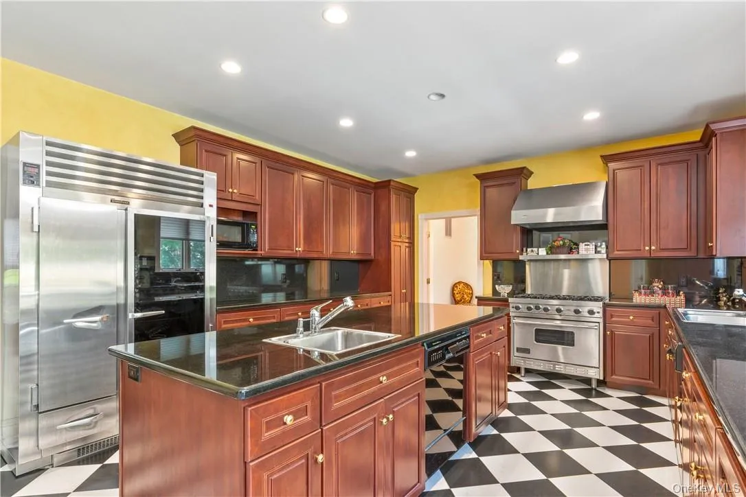 Outstanding kitchen, with custom ccherry cabinets, large island, chef’ s appliances, granite counters and fireplace Outstanding kitchen, with custom ccherry cabinets, large island, chef’ s appliances, granite counters and fireplace