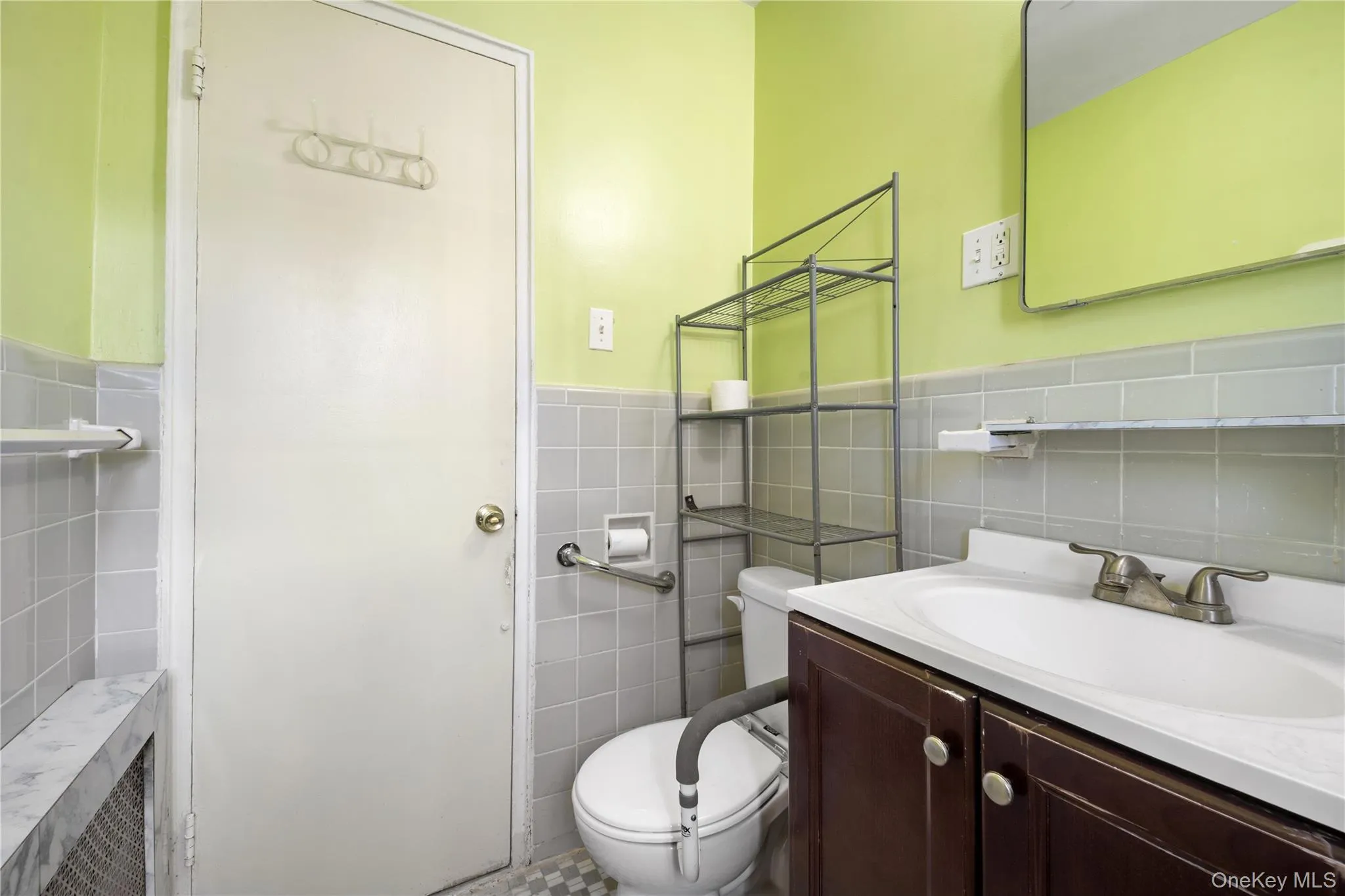 Bathroom with vanity, tile walls, and wainscoting Bathroom with vanity, tile walls, and wainscoting