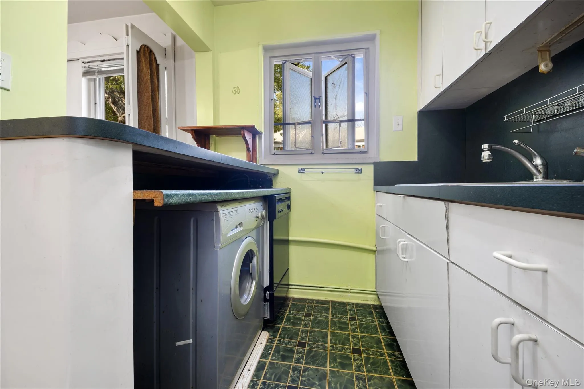 Washroom featuring healthy amount of natural light and washer / clothes dryer Washroom featuring healthy amount of natural light and washer / clothes dryer