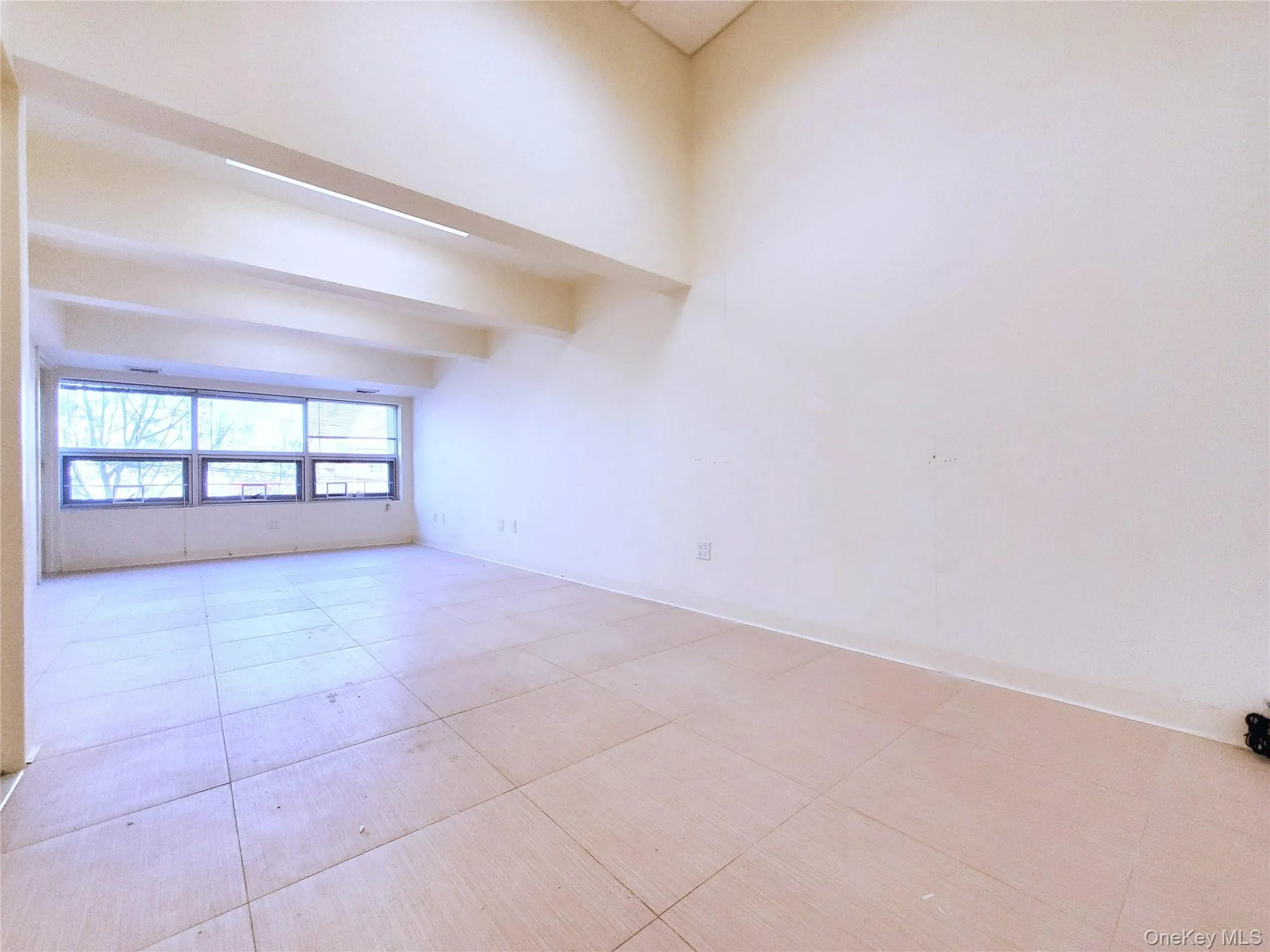 Unfurnished room featuring light tile patterned floors and beam ceiling Unfurnished room featuring light tile patterned floors and beam ceiling