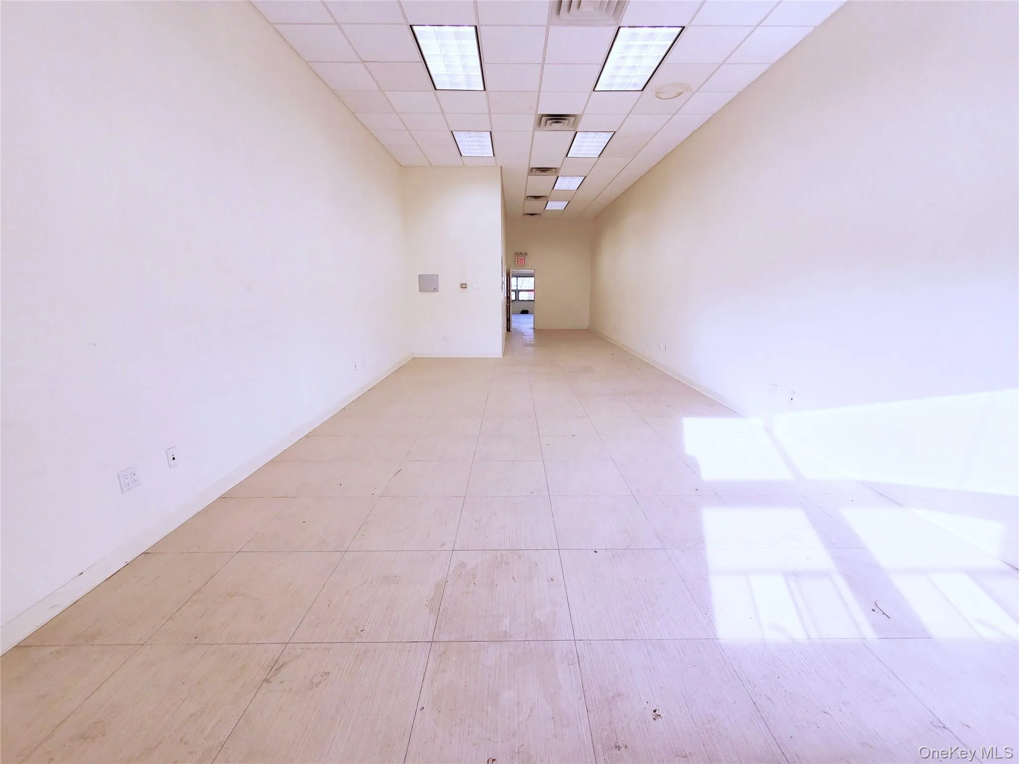 Unfurnished room with a paneled ceiling and baseboards Unfurnished room with a paneled ceiling and baseboards