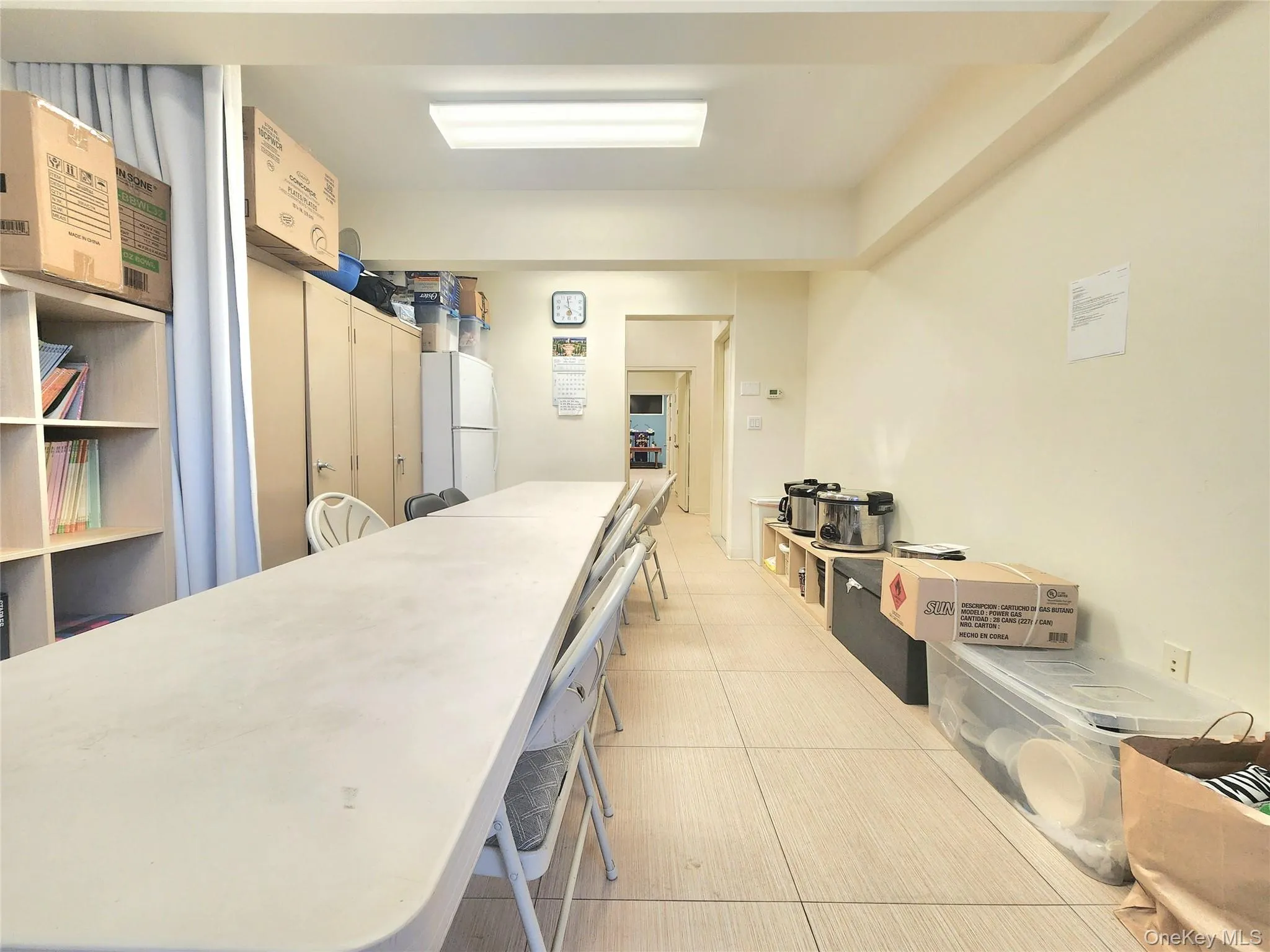 Kitchen with a breakfast bar area, light countertops, and freestanding refrigerator Kitchen with a breakfast bar area, light countertops, and freestanding refrigerator