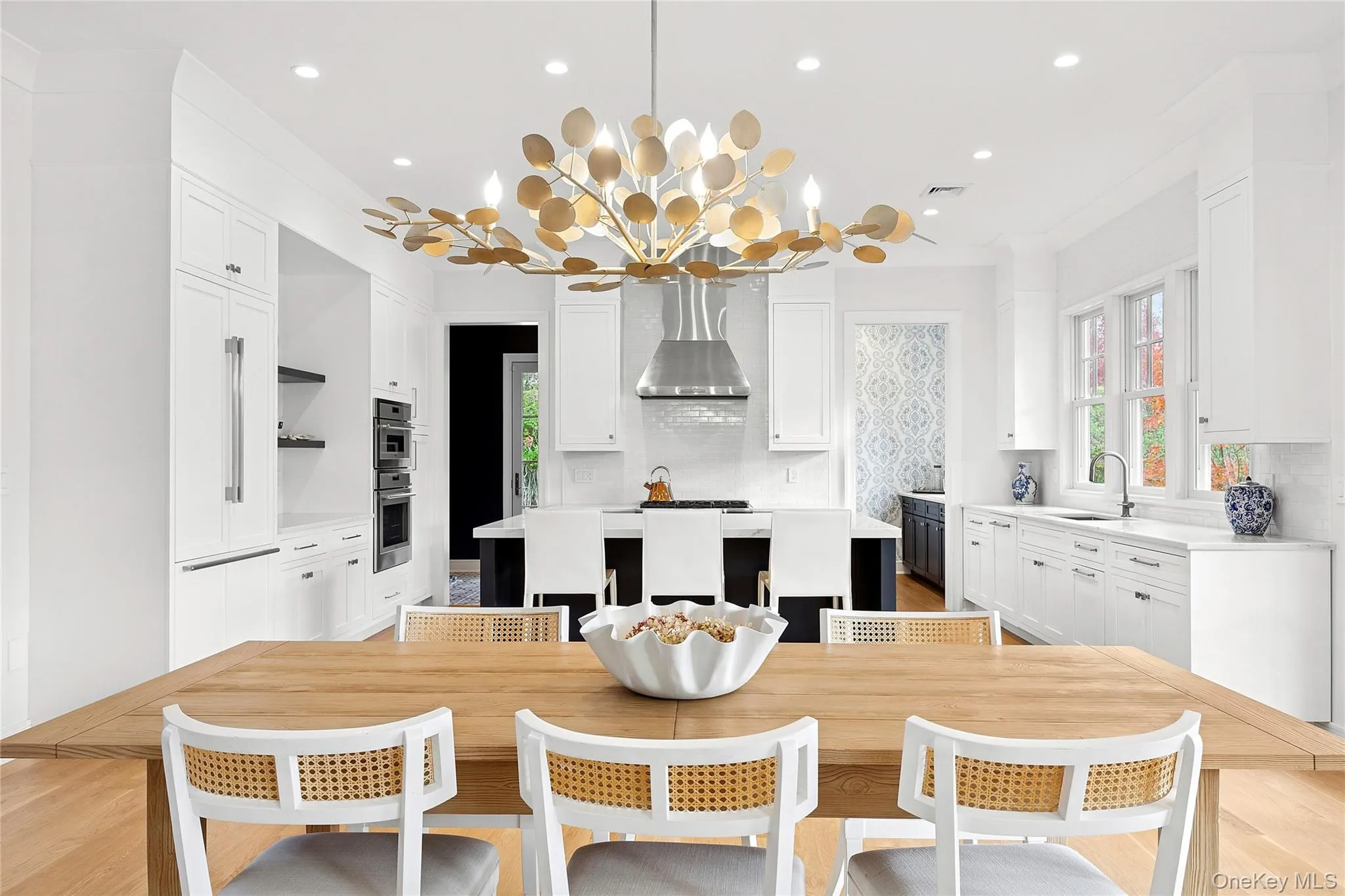 Kitchen with a center island, white cabinets, tasteful backsplash, light wood-style floors, and recessed lighting Kitchen with a center island, white cabinets, tasteful backsplash, light wood-style floors, and recessed lighting
