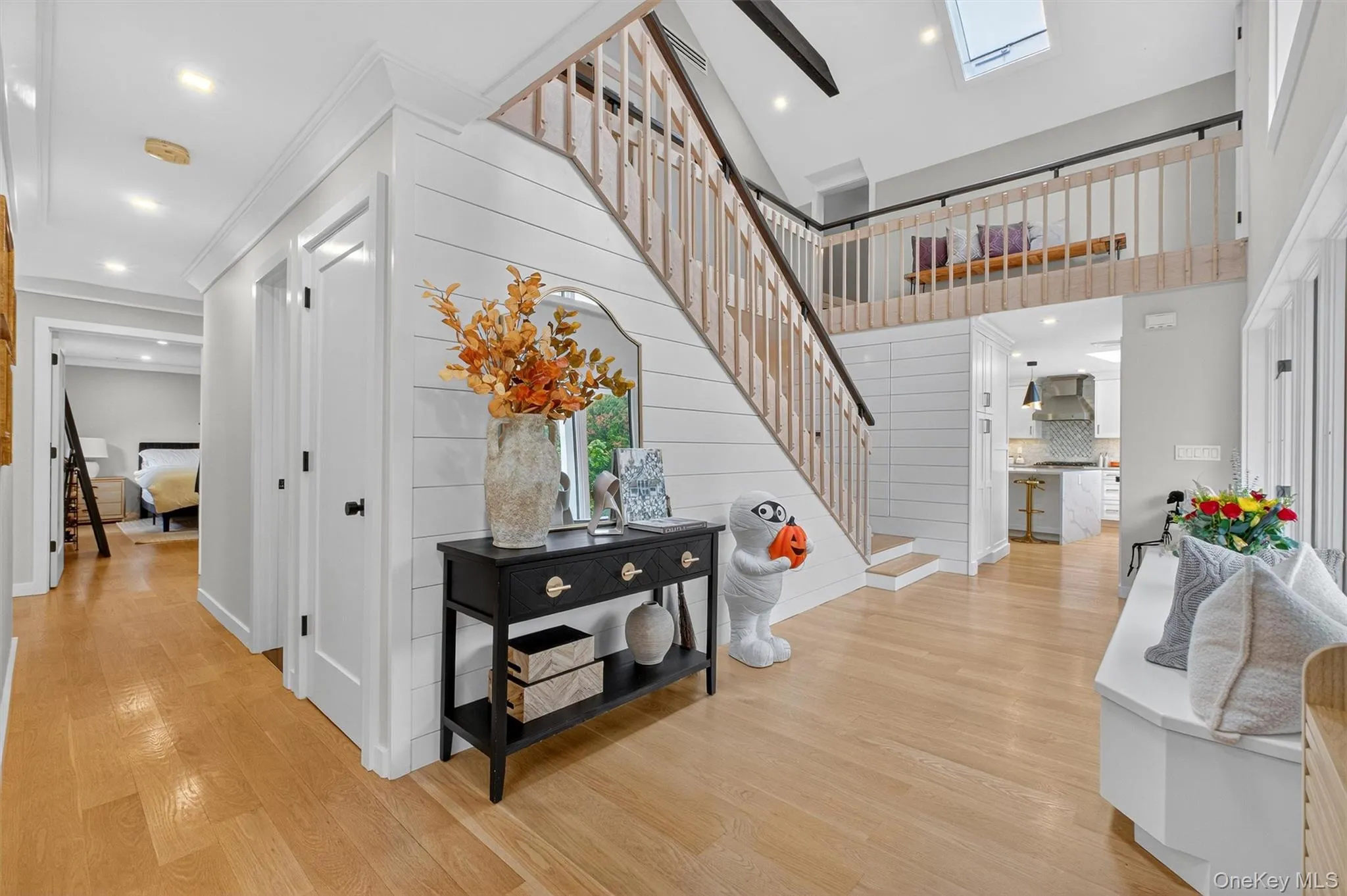 Entrance foyer featuring stairway, light wood flooring, a high ceiling, a skylight, and recessed lighting Entrance foyer featuring stairway, light wood flooring, a high ceiling, a skylight, and recessed lighting