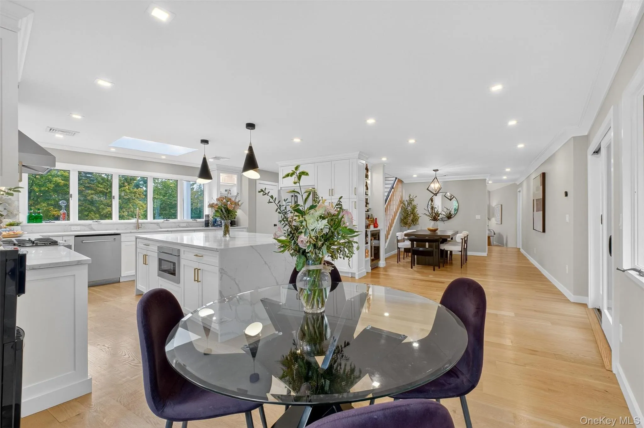 Eat-in kitchen space featuring light wood floors, a skylight, recessed lighting, crown molding Eat-in kitchen space featuring light wood floors, a skylight, recessed lighting, crown molding