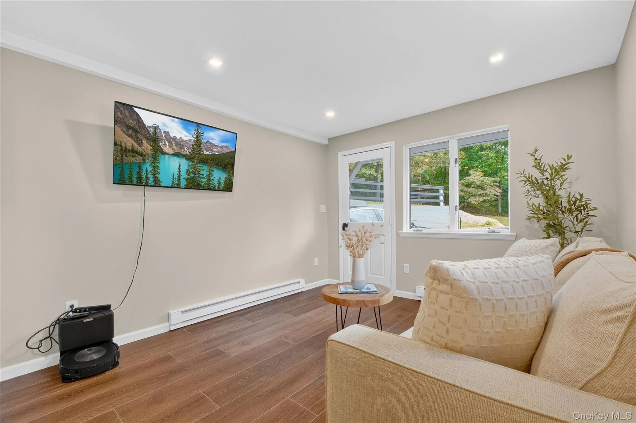 Sitting area wood finished floors, door to outside, and recessed lighting Sitting area wood finished floors, door to outside, and recessed lighting