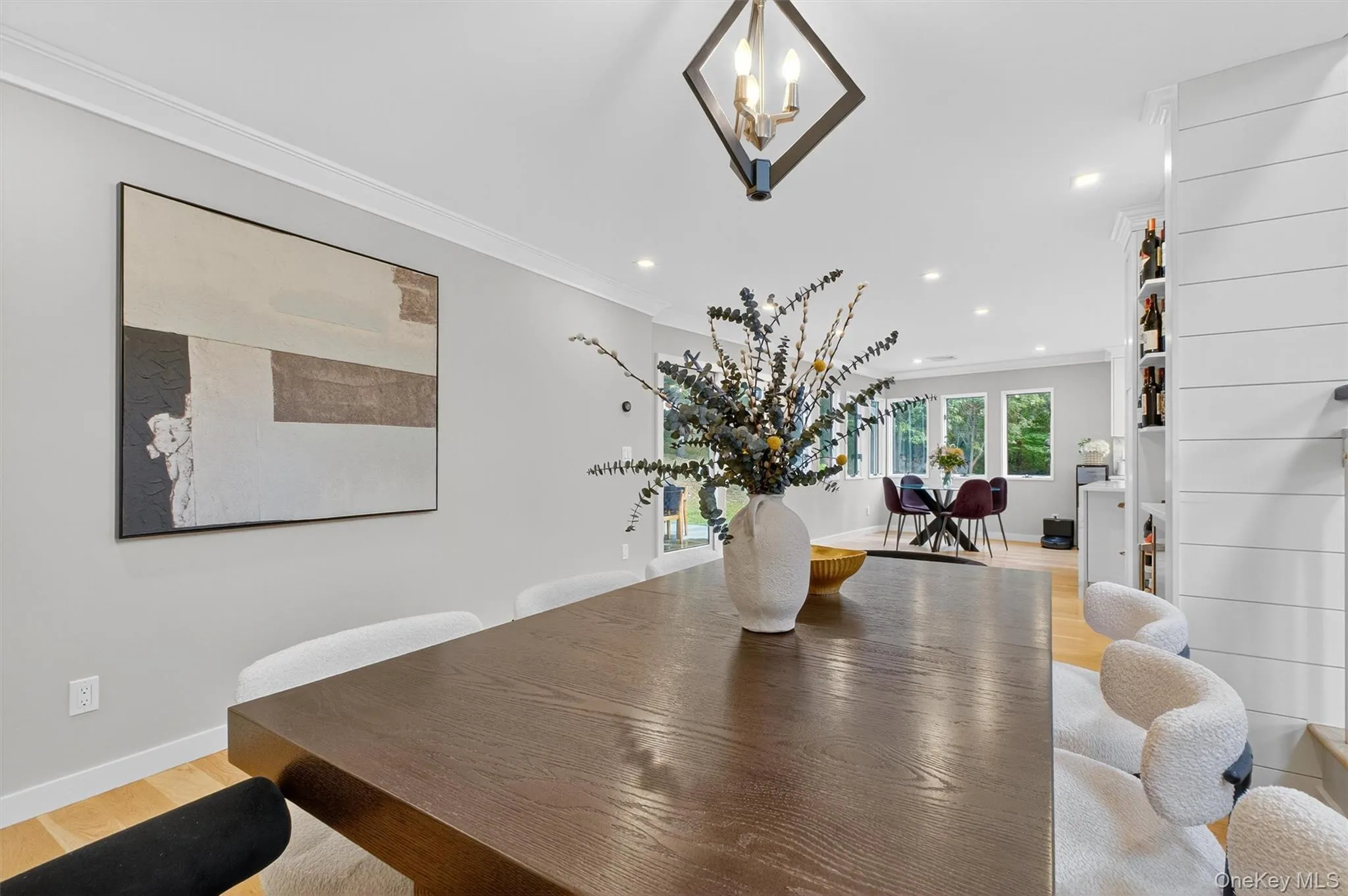 Dining area with light wood  floors, ornamental molding, recessed lighting, and a chandelier Dining area with light wood  floors, ornamental molding, recessed lighting, and a chandelier